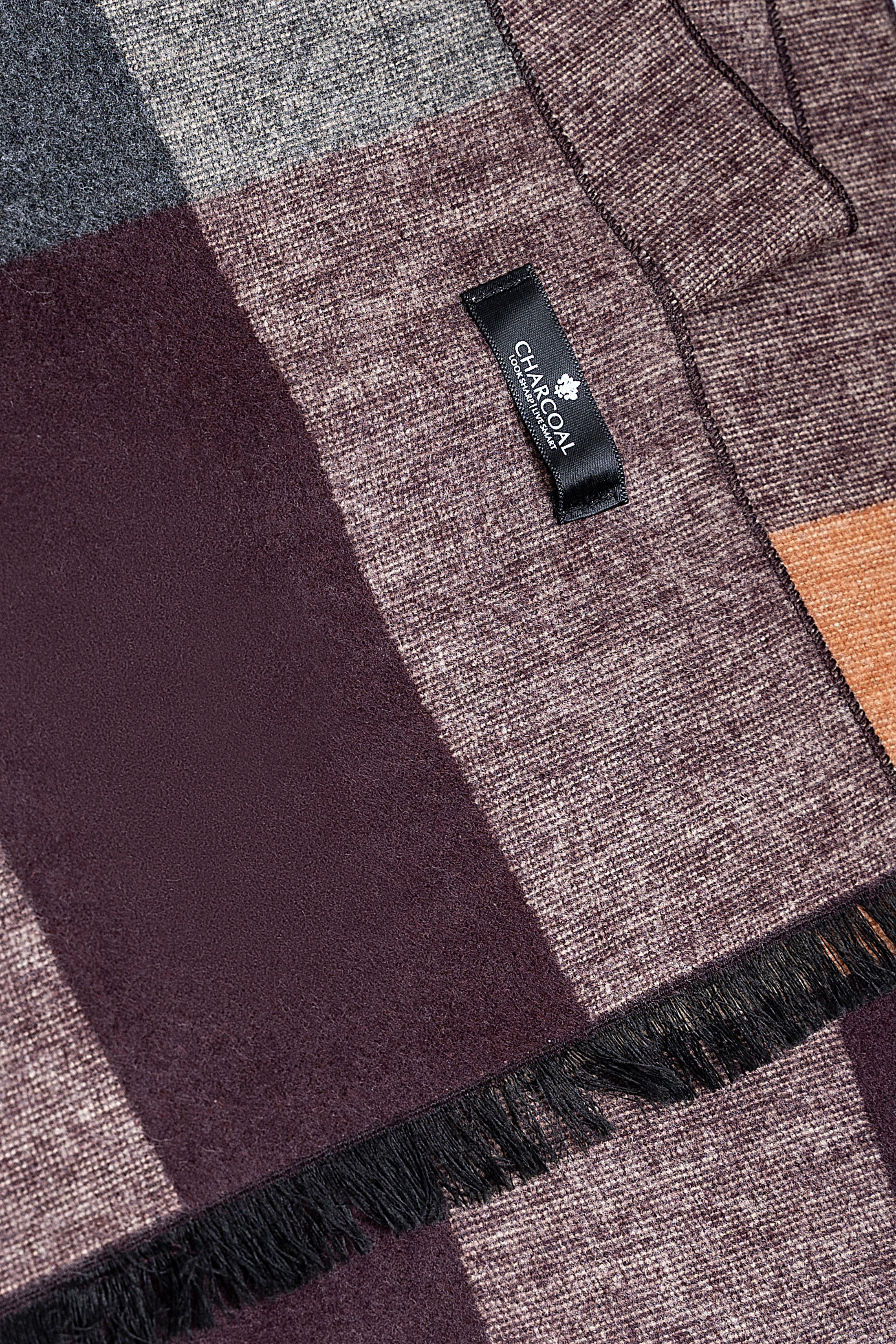 Scarf close-up with Calvin Klein label on maroon, gray, tan fabric