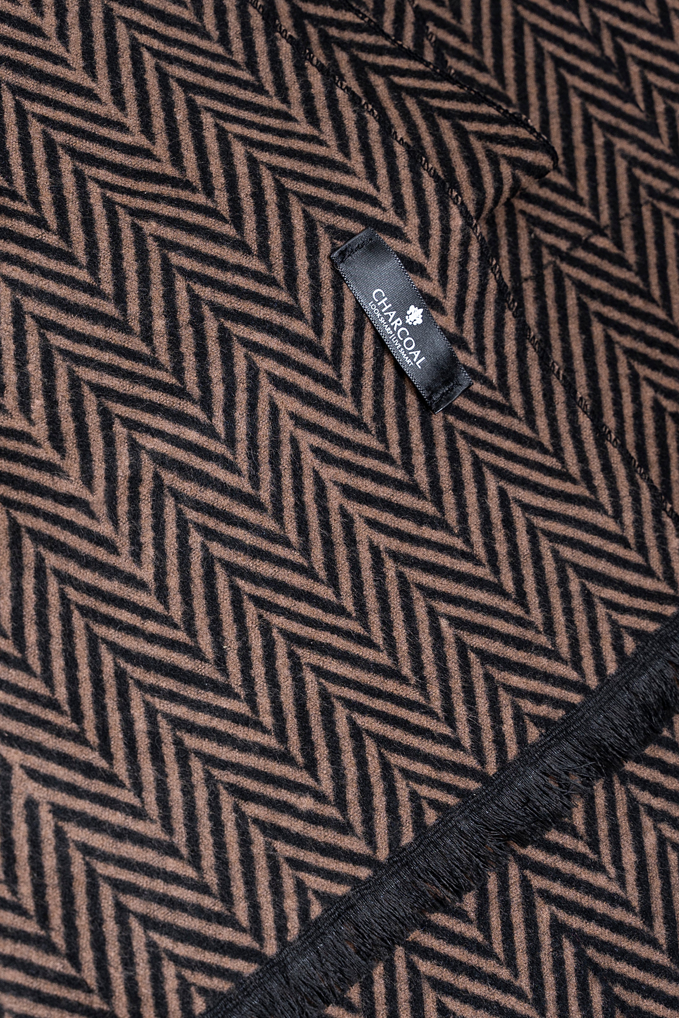 Scarf fabric close-up with black-and-tan chevron zigzag weave and woven brand label