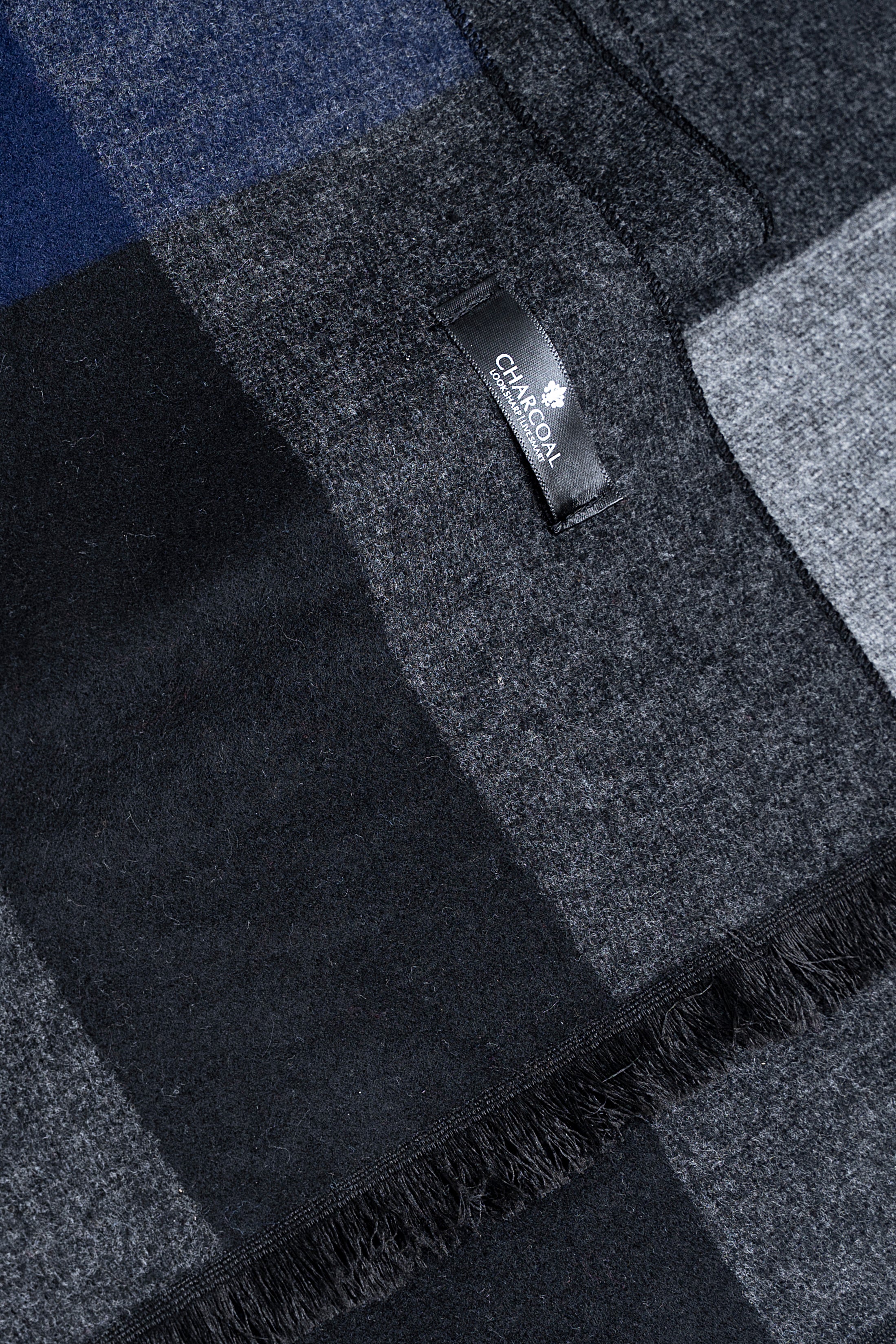 Close-up of dark blue-gray check scarf label and fringed edge