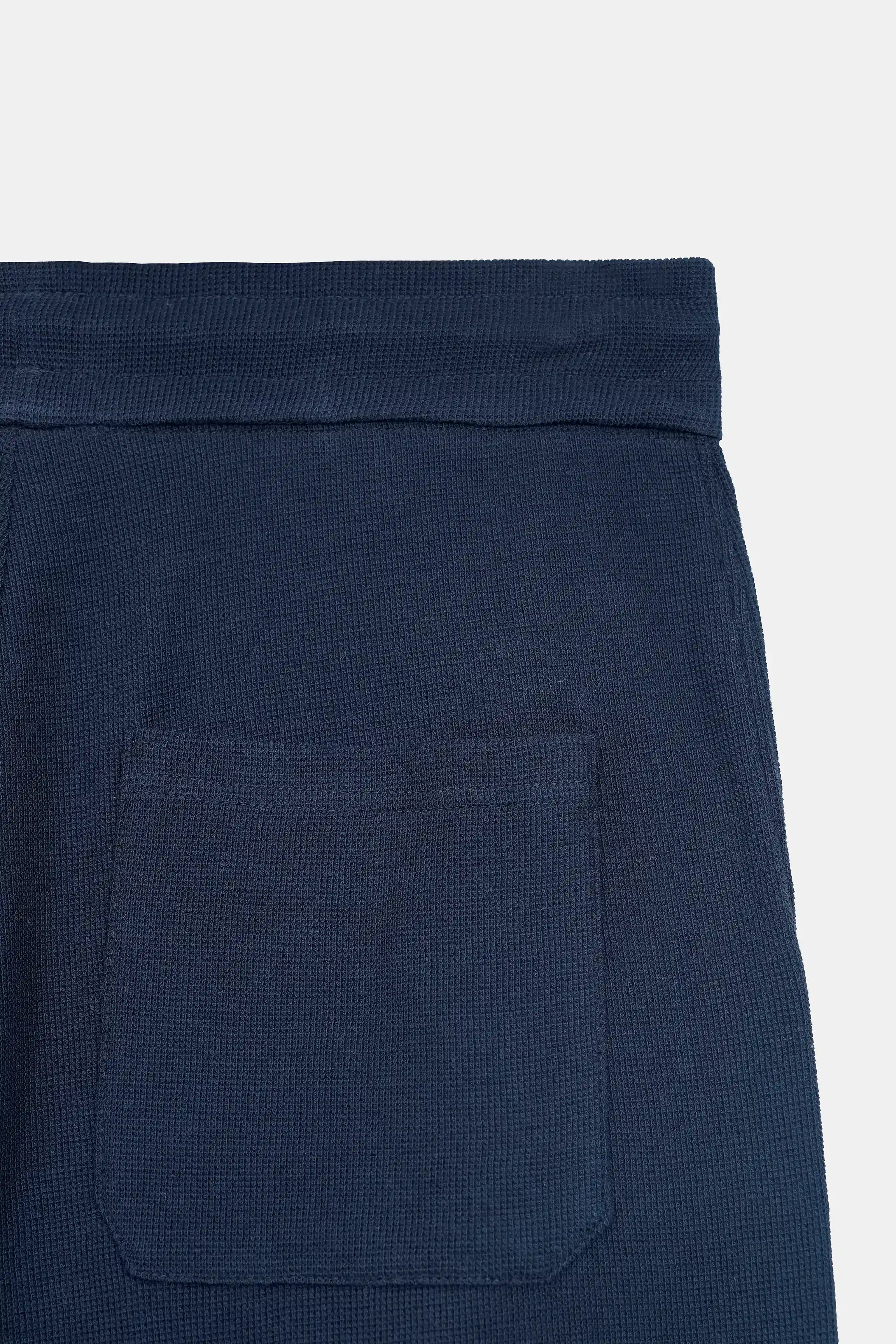 Navy knit trousers with front patch pocket and elastic cuff