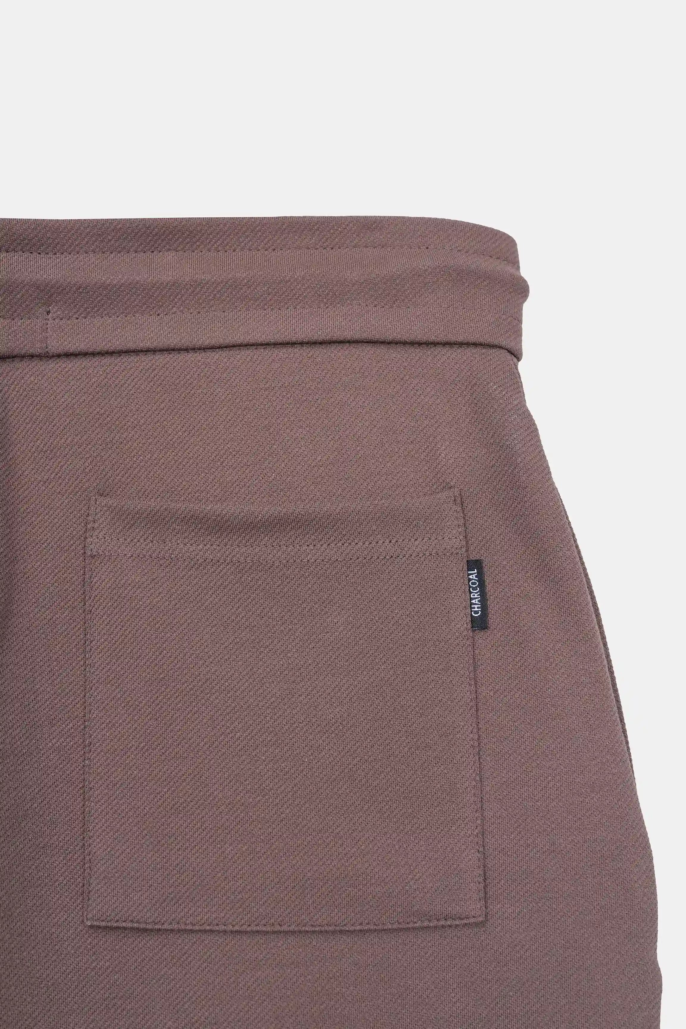 Rust-brown shorts with side pocket and small logo label detail.