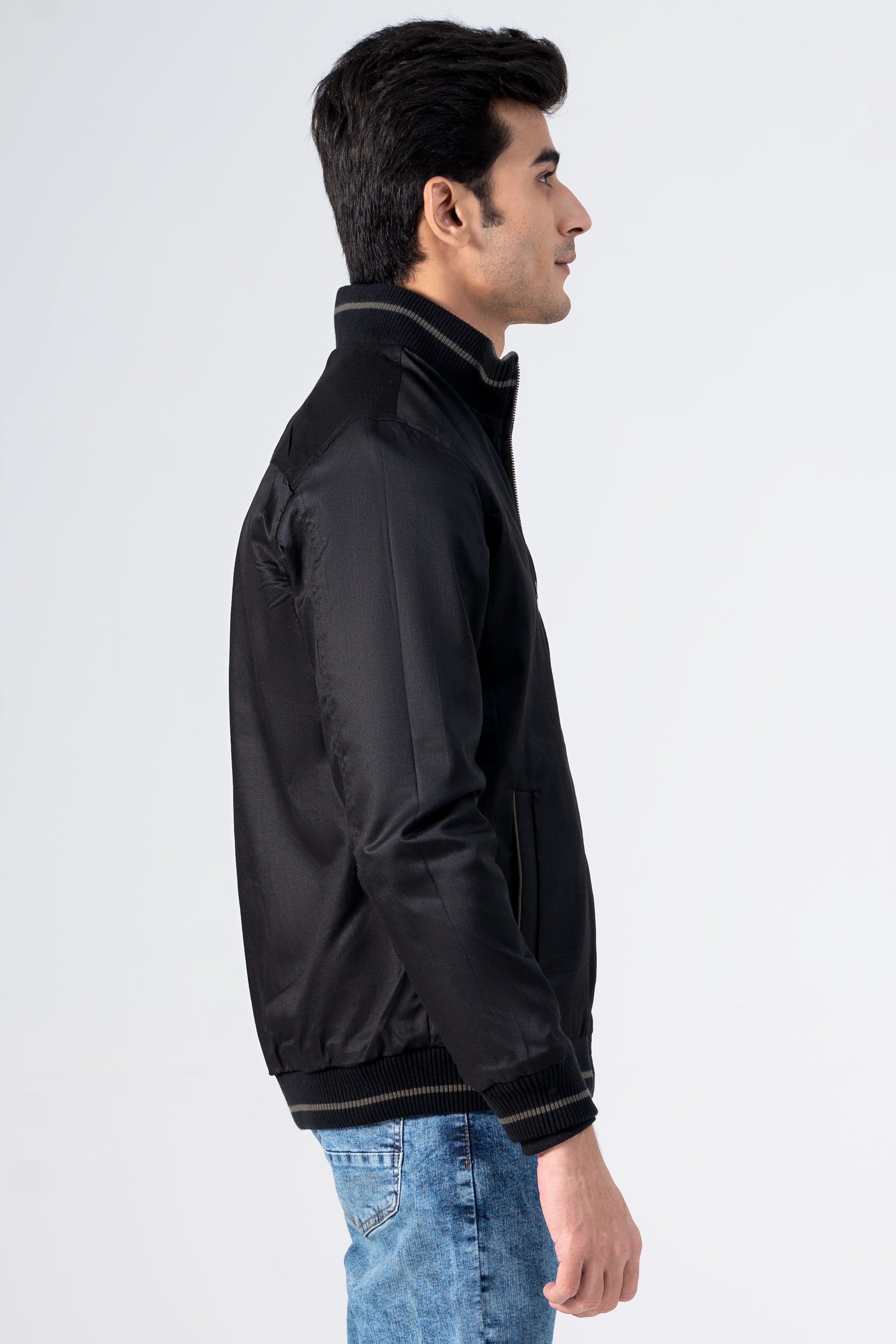 Reversible jacket in black with stand collar, zip front and ribbed cuffs, side view