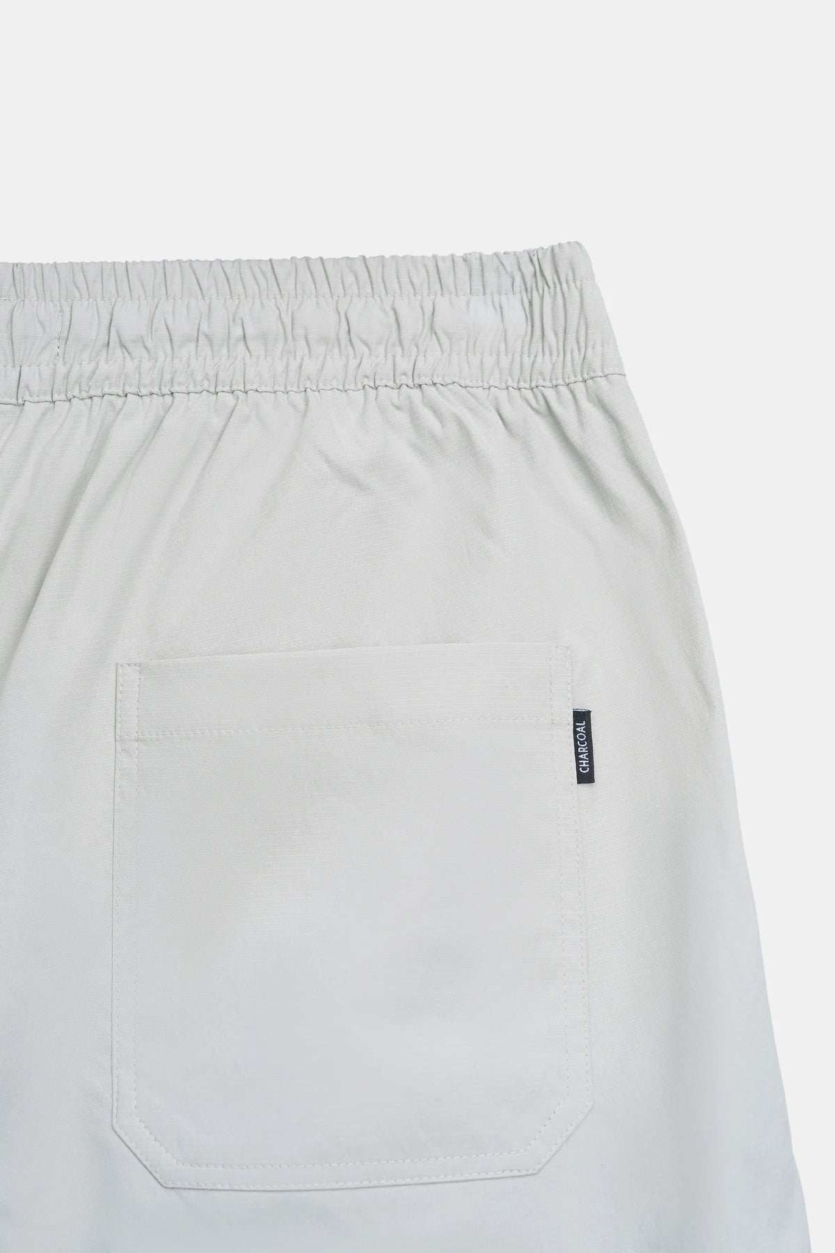 Stone casual trousers with side pocket and small logo label on the front