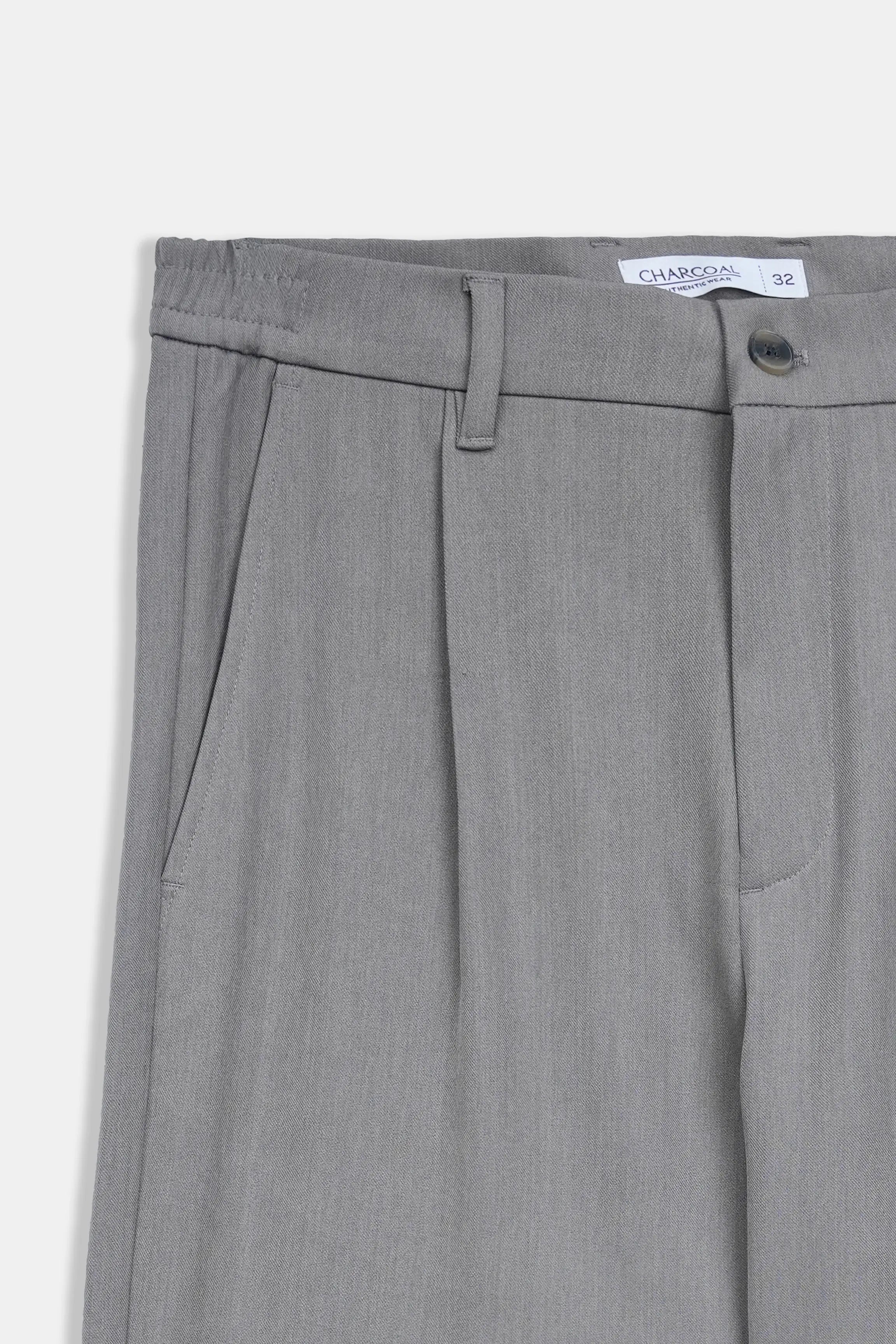 Grey pants waistband detail with belt loops, front pleats, and button