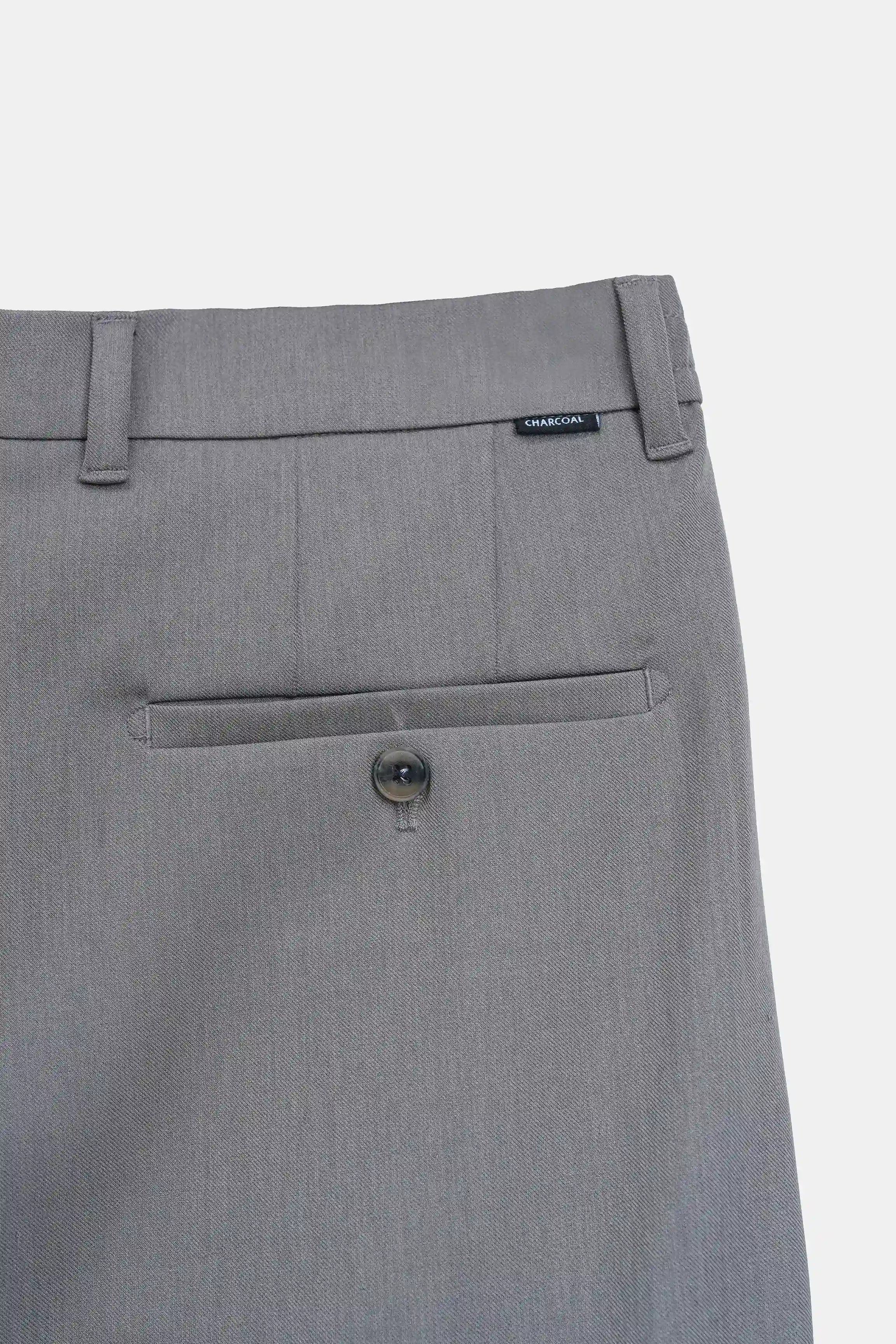 Grey pants front pocket and button closure detail with belt loops