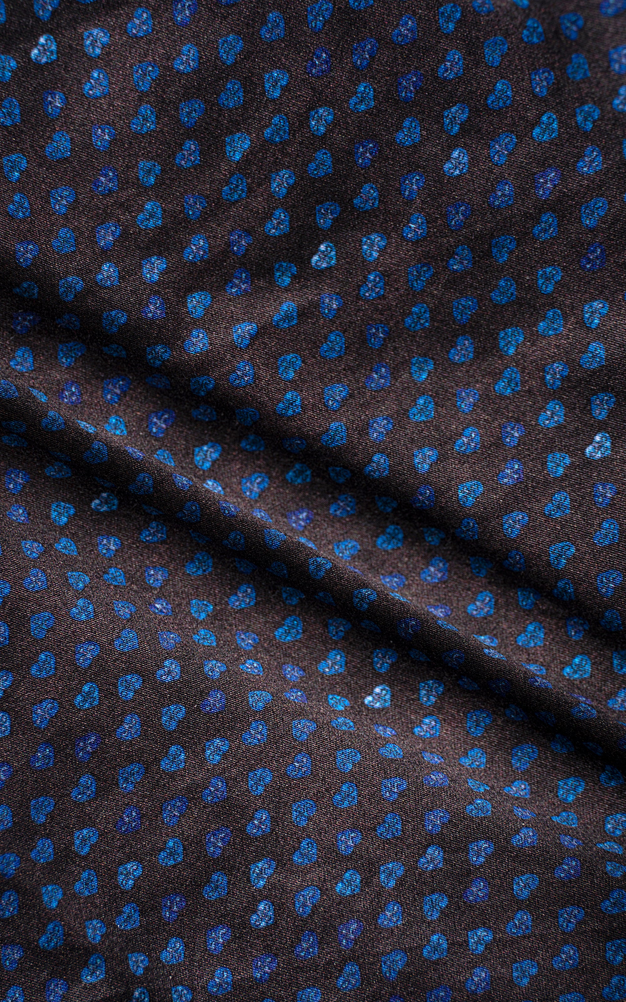 Dark brown shirt fabric with blue dot pattern, close-up texture