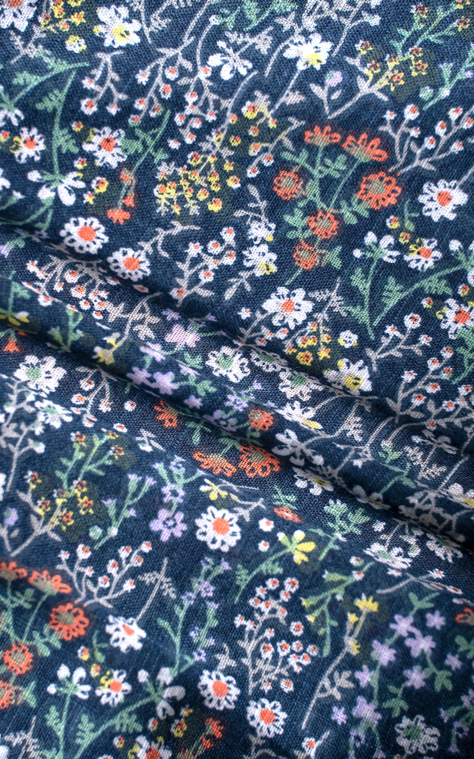 Forest green floral shirt fabric close-up with multicolor blossoms