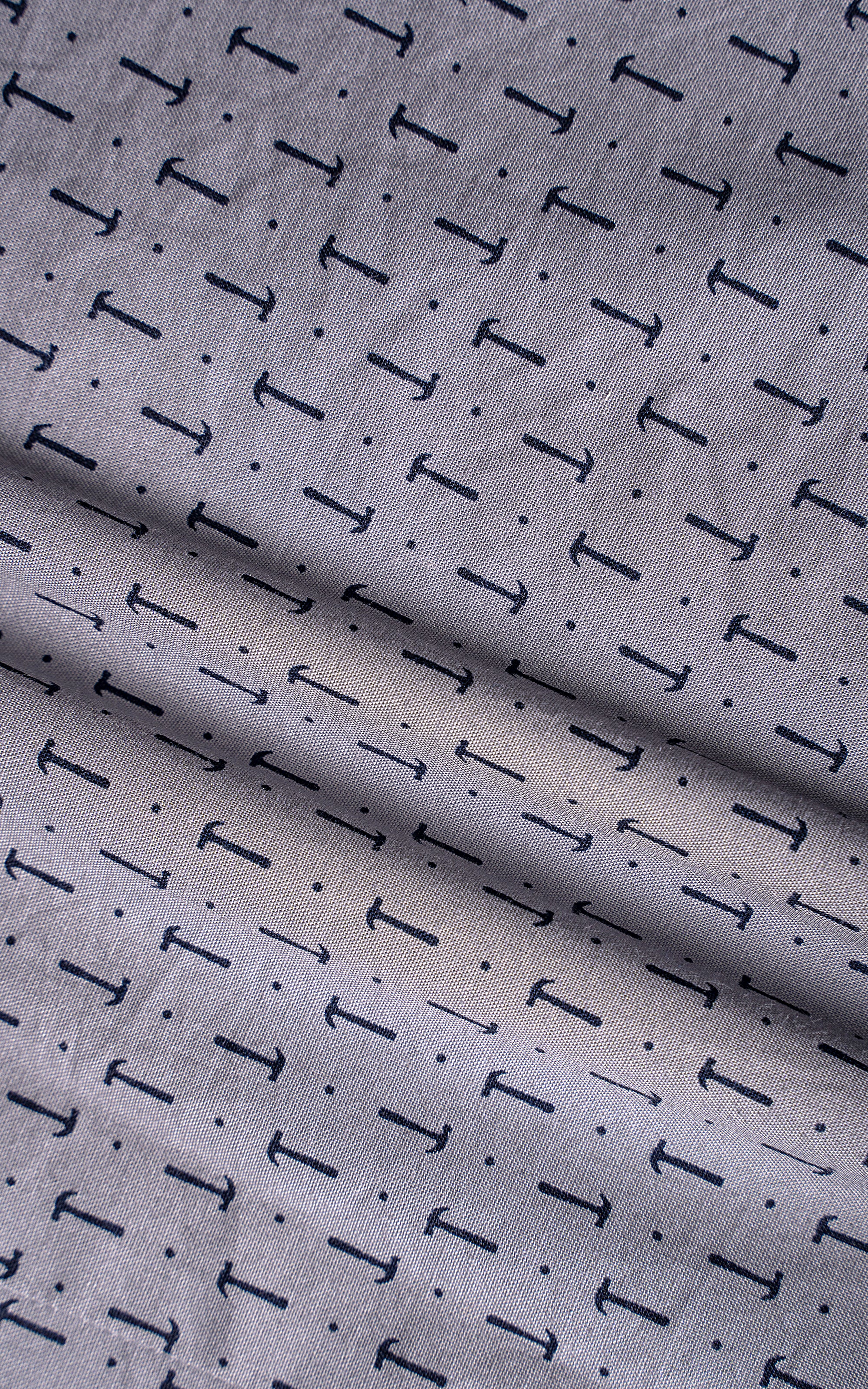 Light grey dress shirt fabric with repeating dark T-shaped pattern