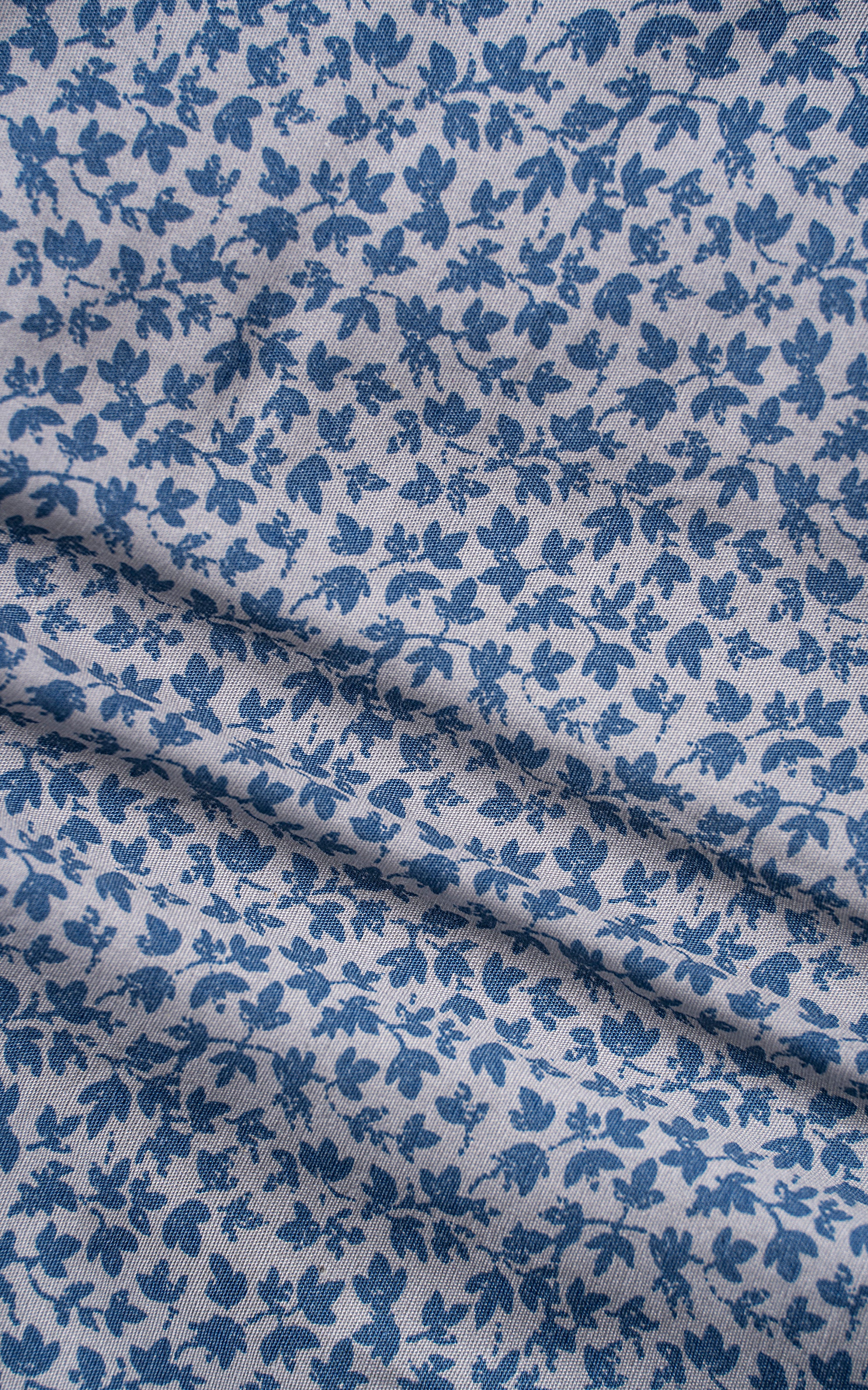 Close-up of light blue floral patterned shirt fabric