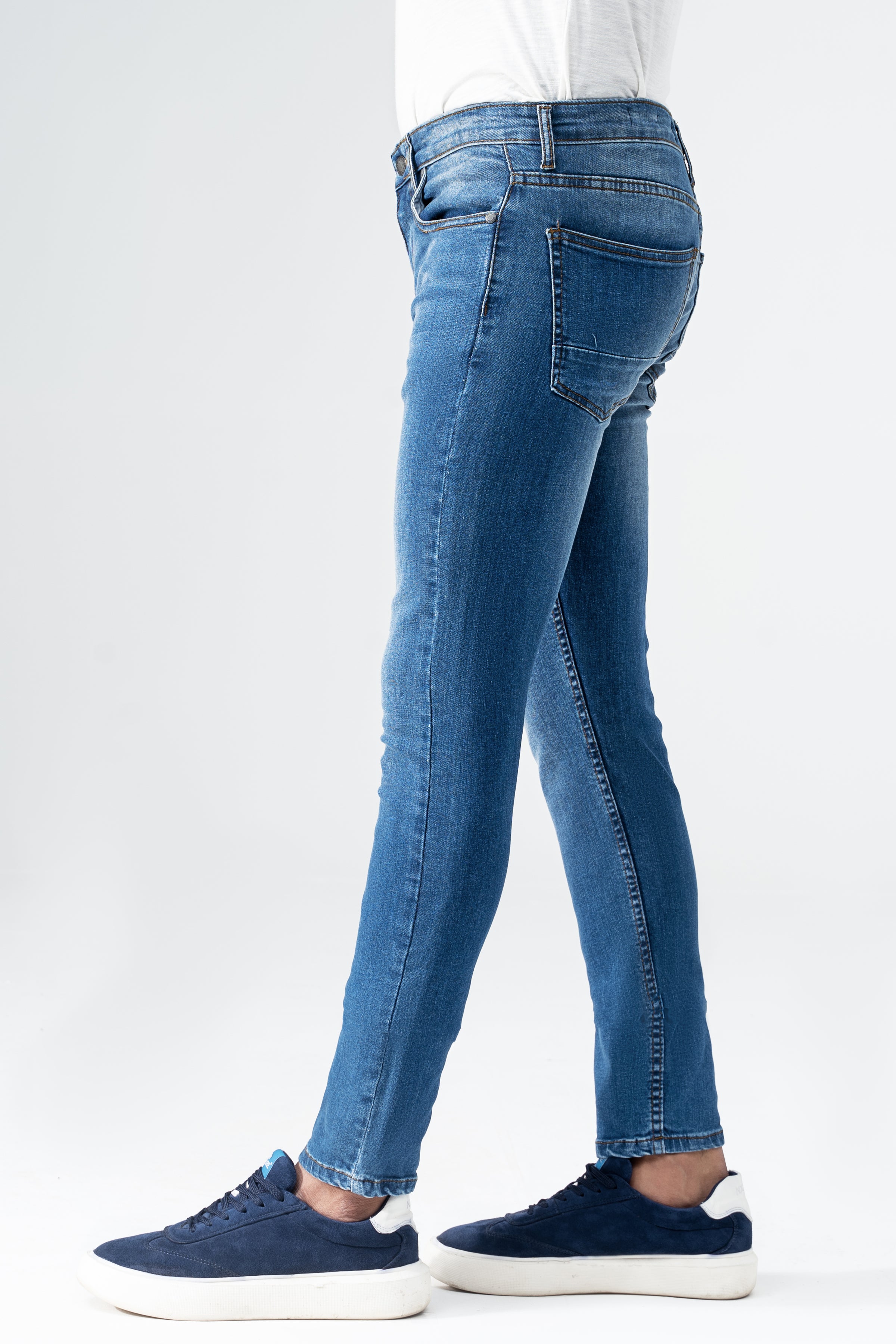 Mid blue slim leg denim jeans with back yoke and stitched seams, ankle-length