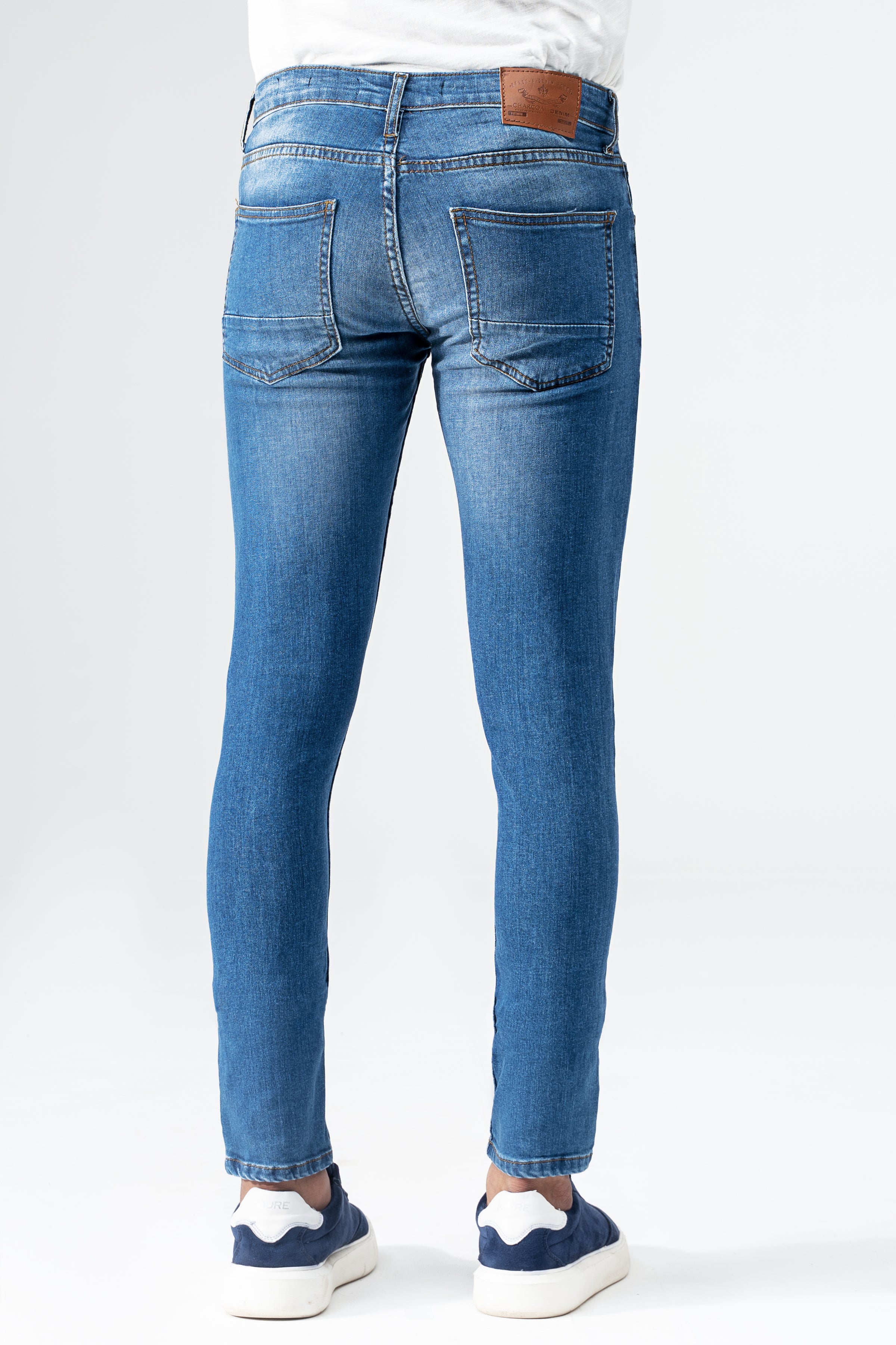 Mid blue slim leg denim jeans with back patch label and slim knee-to-ankle fit