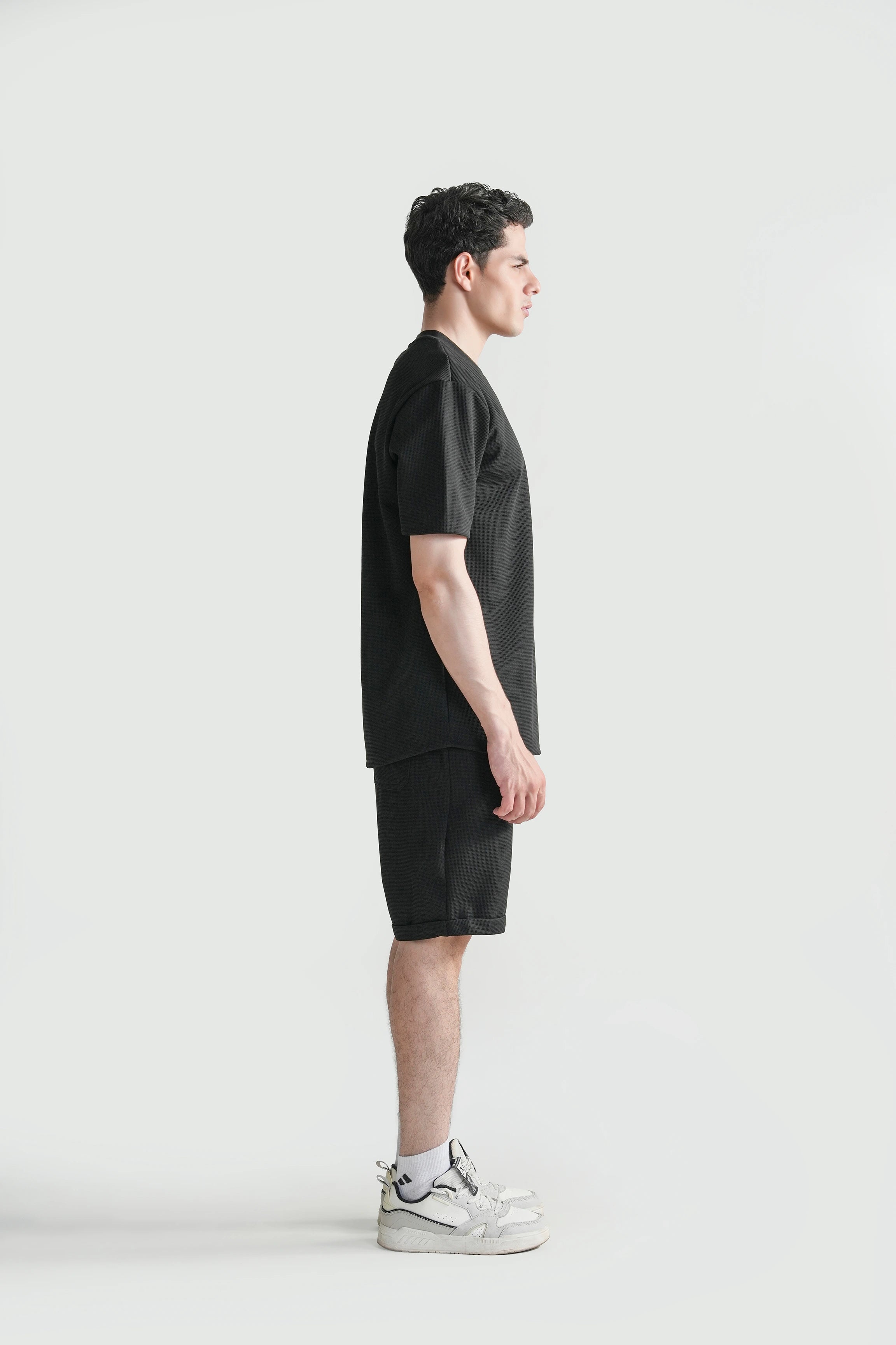 Oversize crew neck T-shirt in black, side view with relaxed shoulders and hem