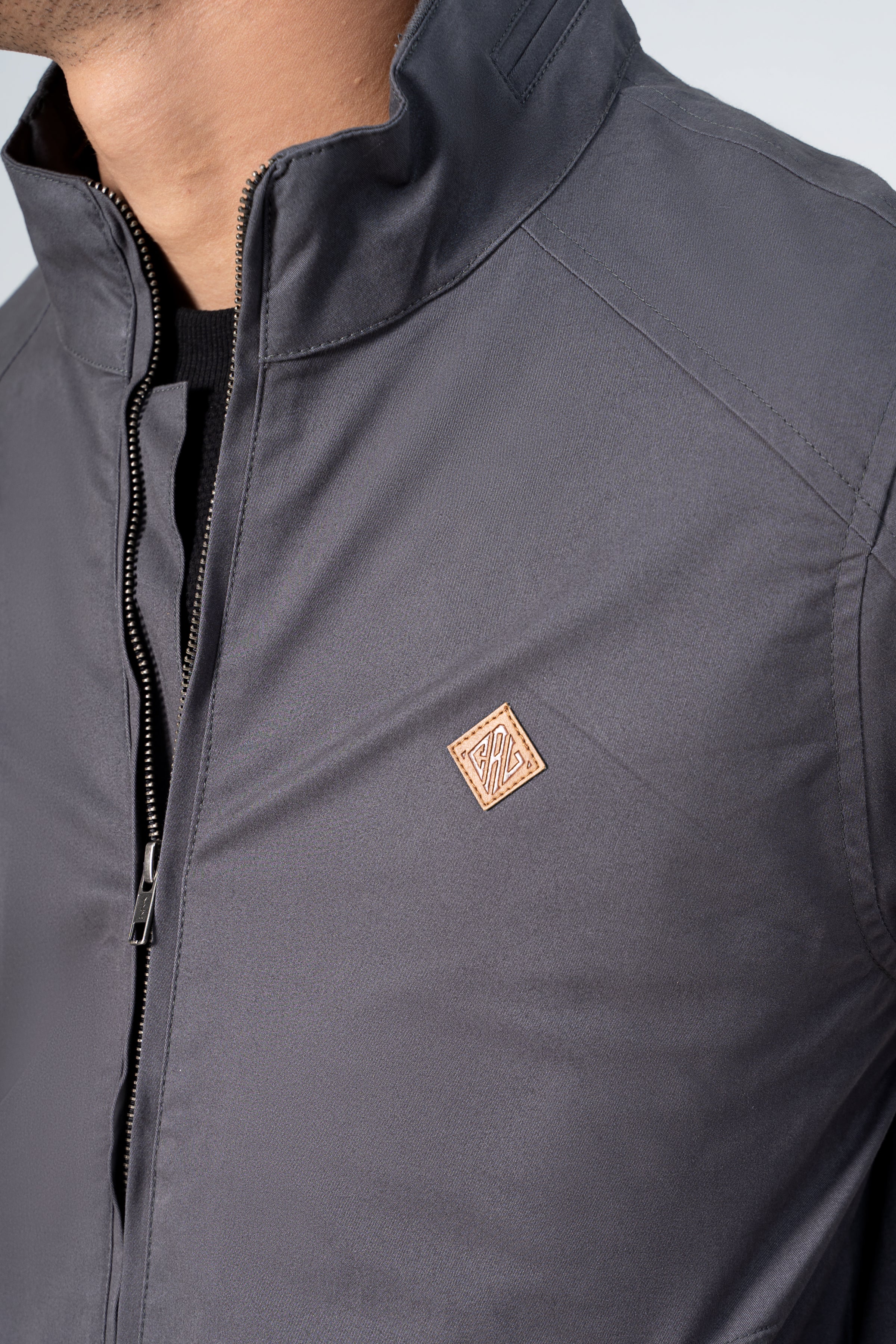 Grey cotton jacket detail with zip front, stand collar and chest logo patch