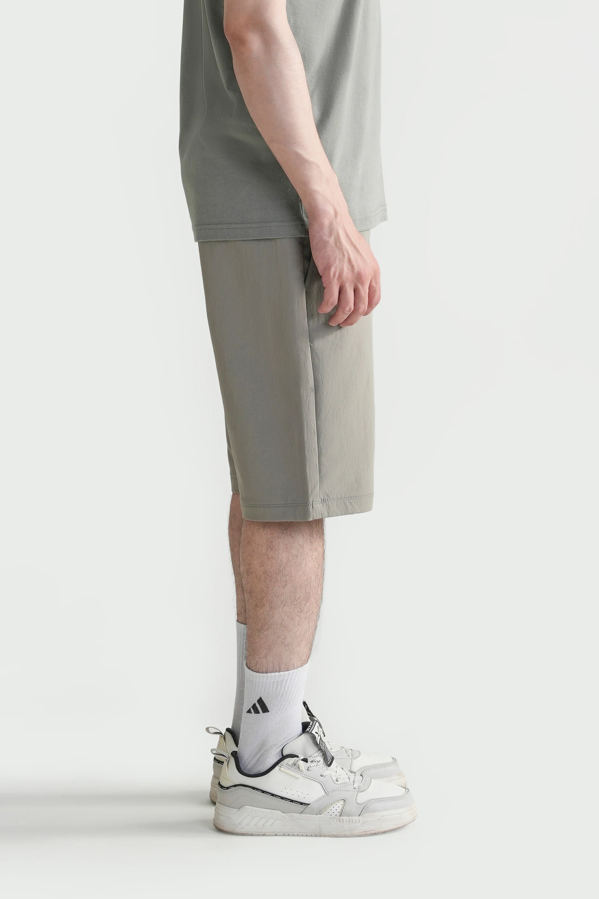Olive regular-fit shorts, side view with straight leg and cuffed hem.