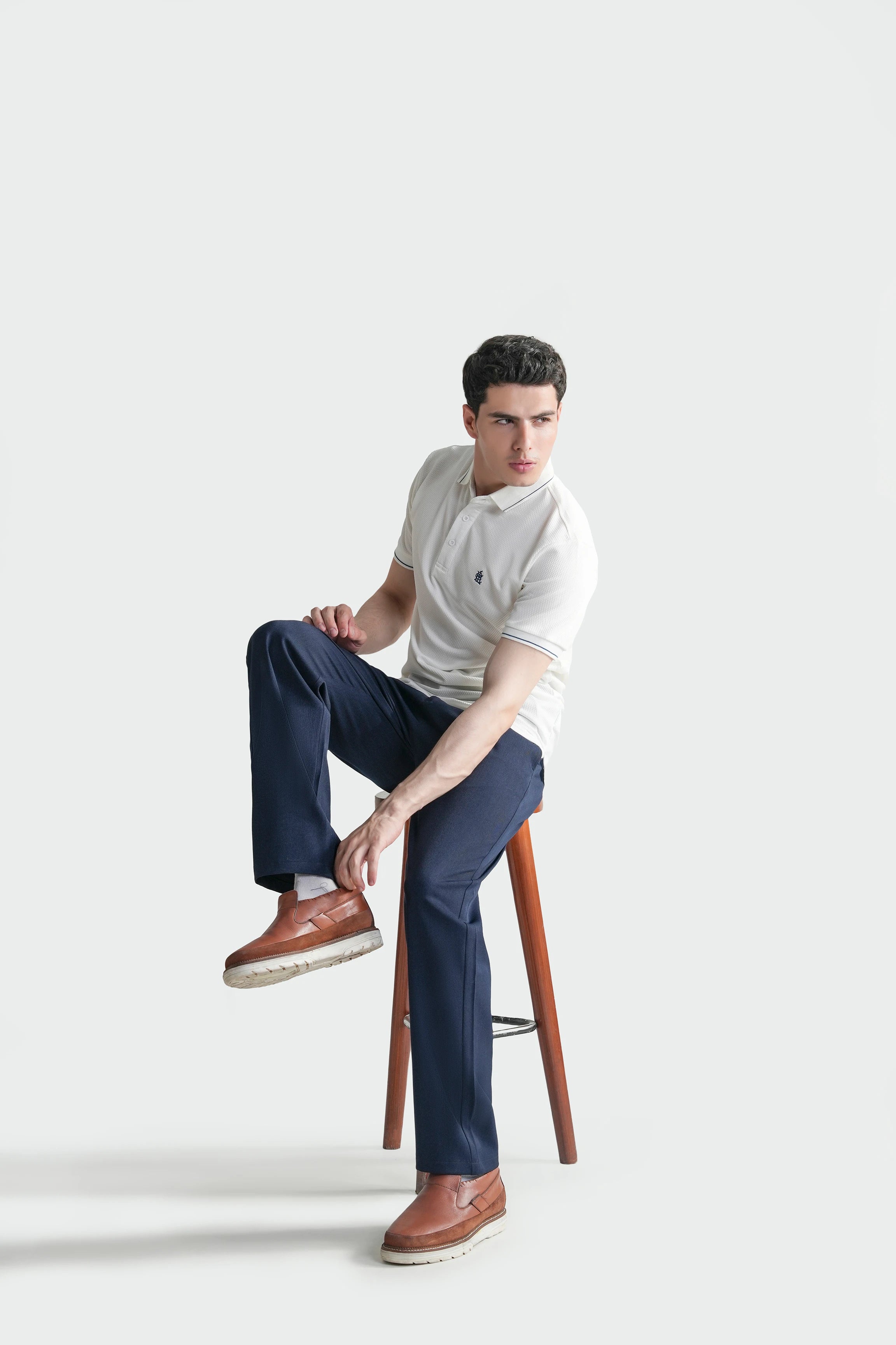 Blue straight-leg casual pants with relaxed fit and rolled cuffs, worn with shoes