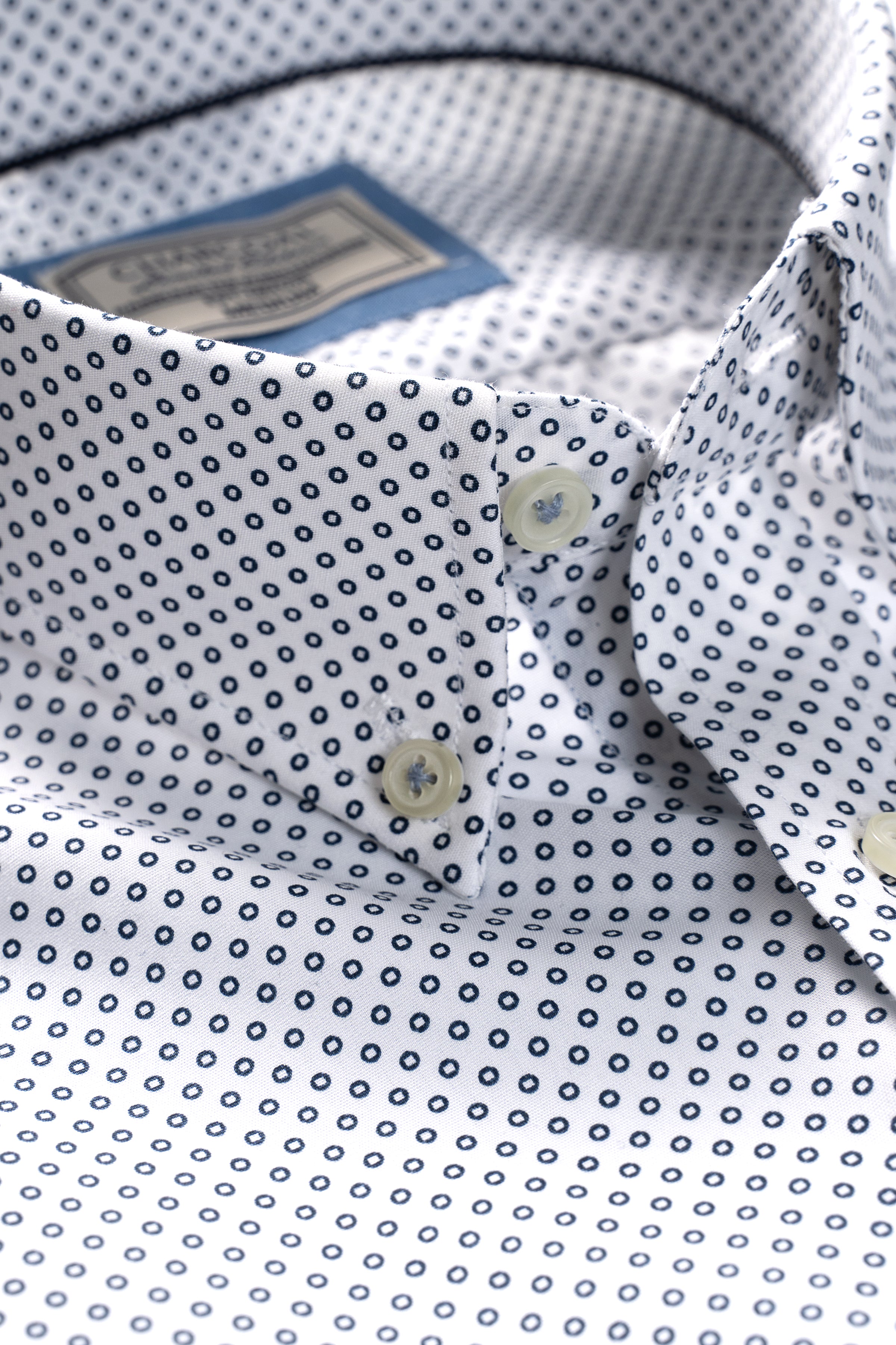 White half-sleeve shirt with repeating small dot pattern, pocket detail and buttons