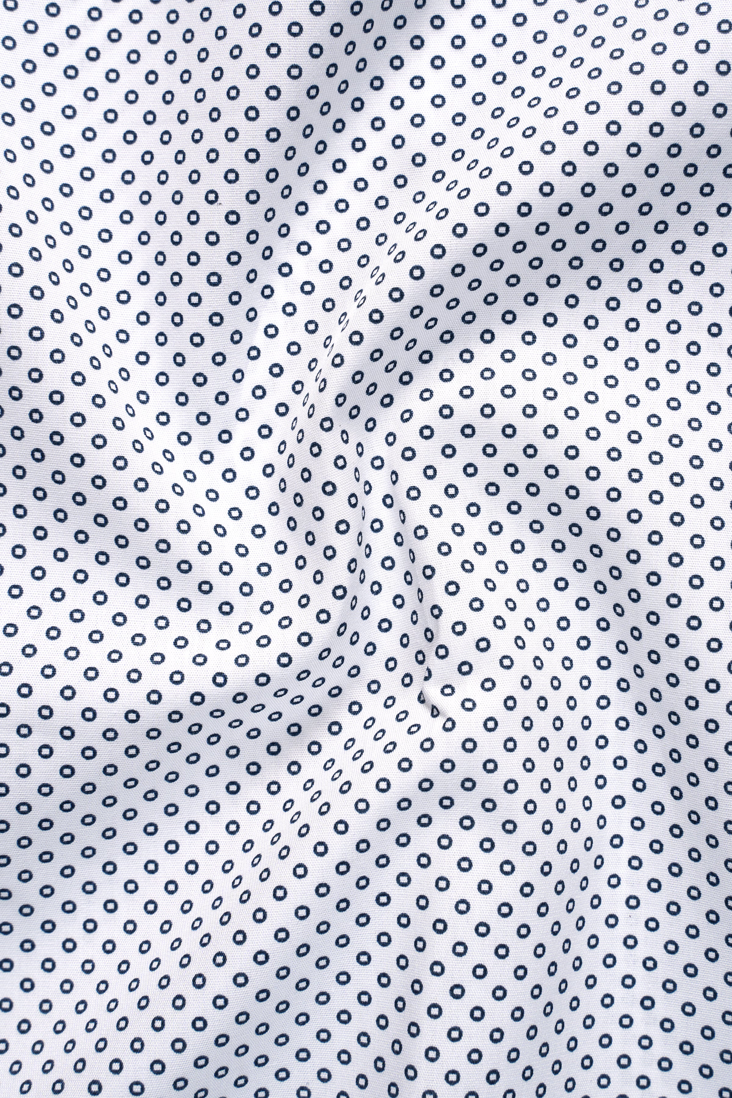 Close-up of white half-sleeve shirt fabric with small dark circles pattern