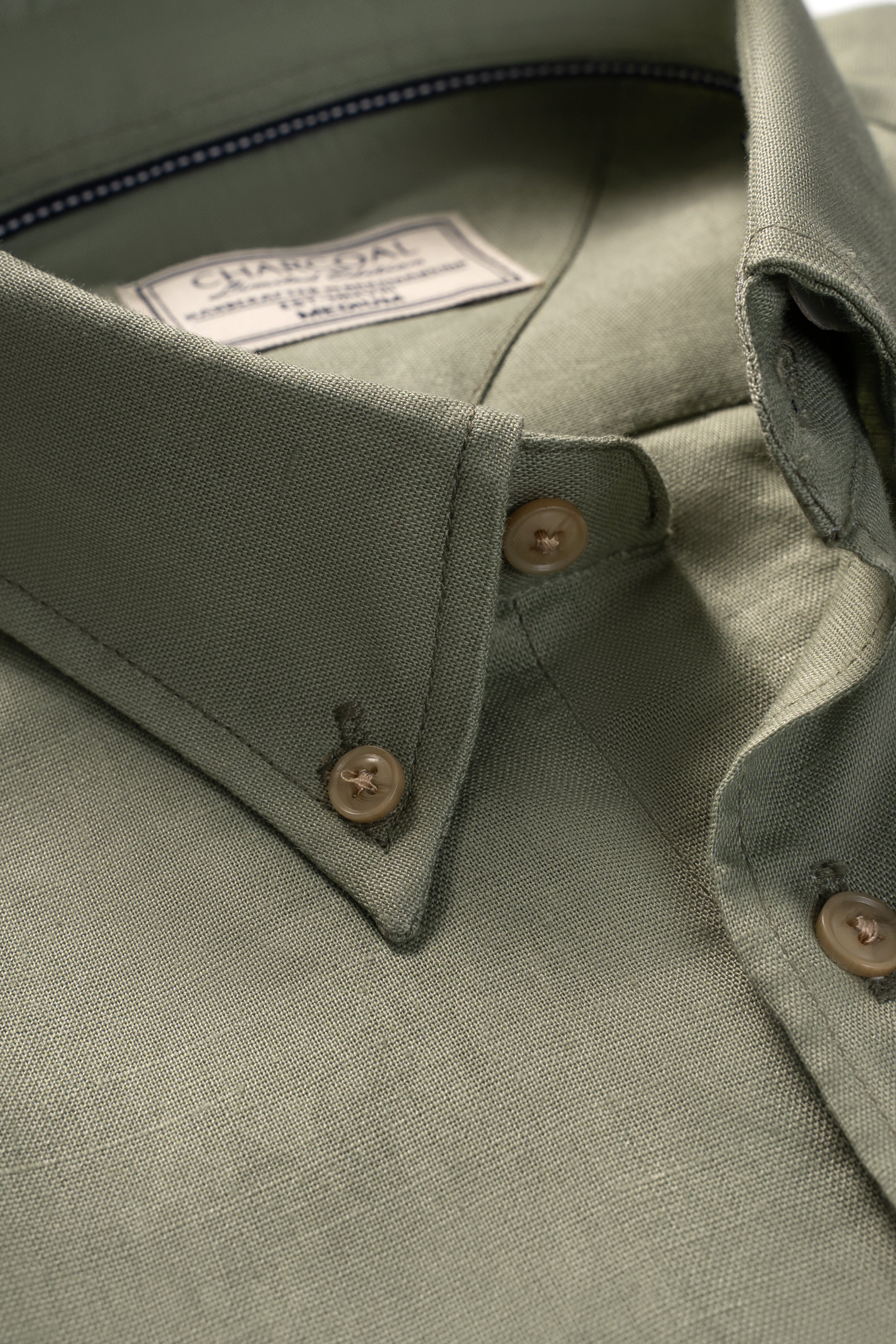 Olive linen fabric shirt collar and brown buttons close-up