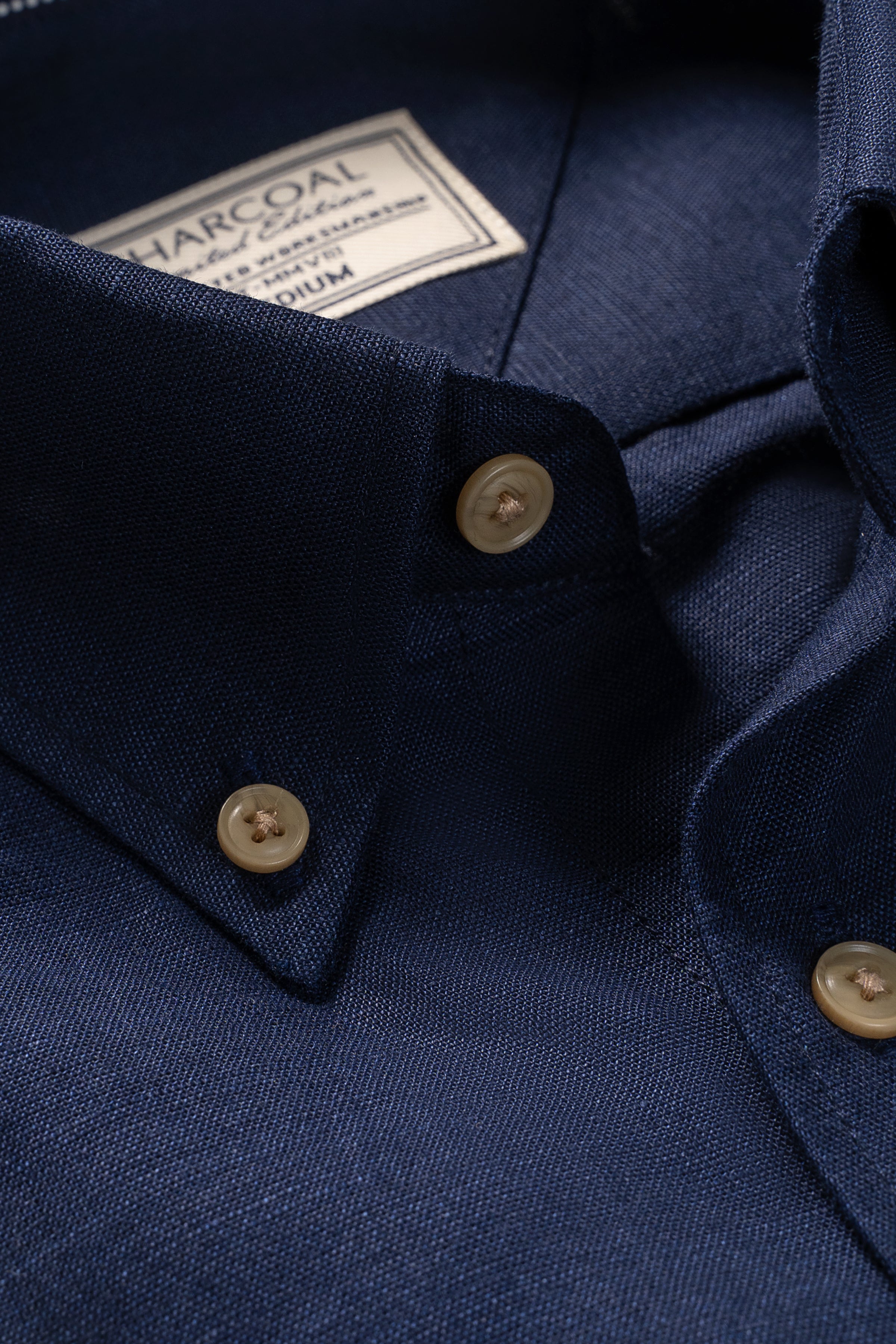 Navy linen shirt close-up of V-neck placket and beige buttons