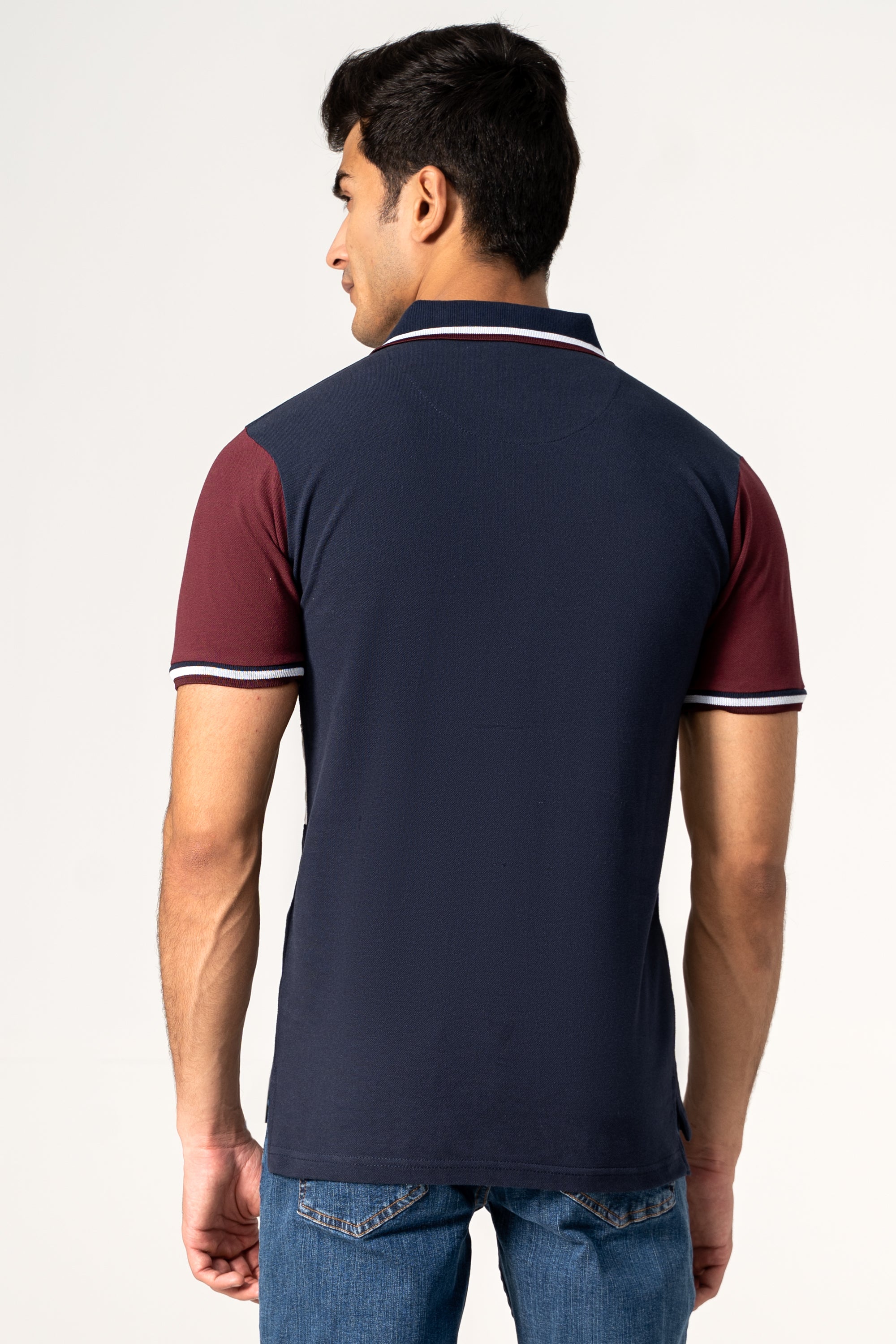 Back view of navy polo shirt with maroon sleeves and white stripe collar edging