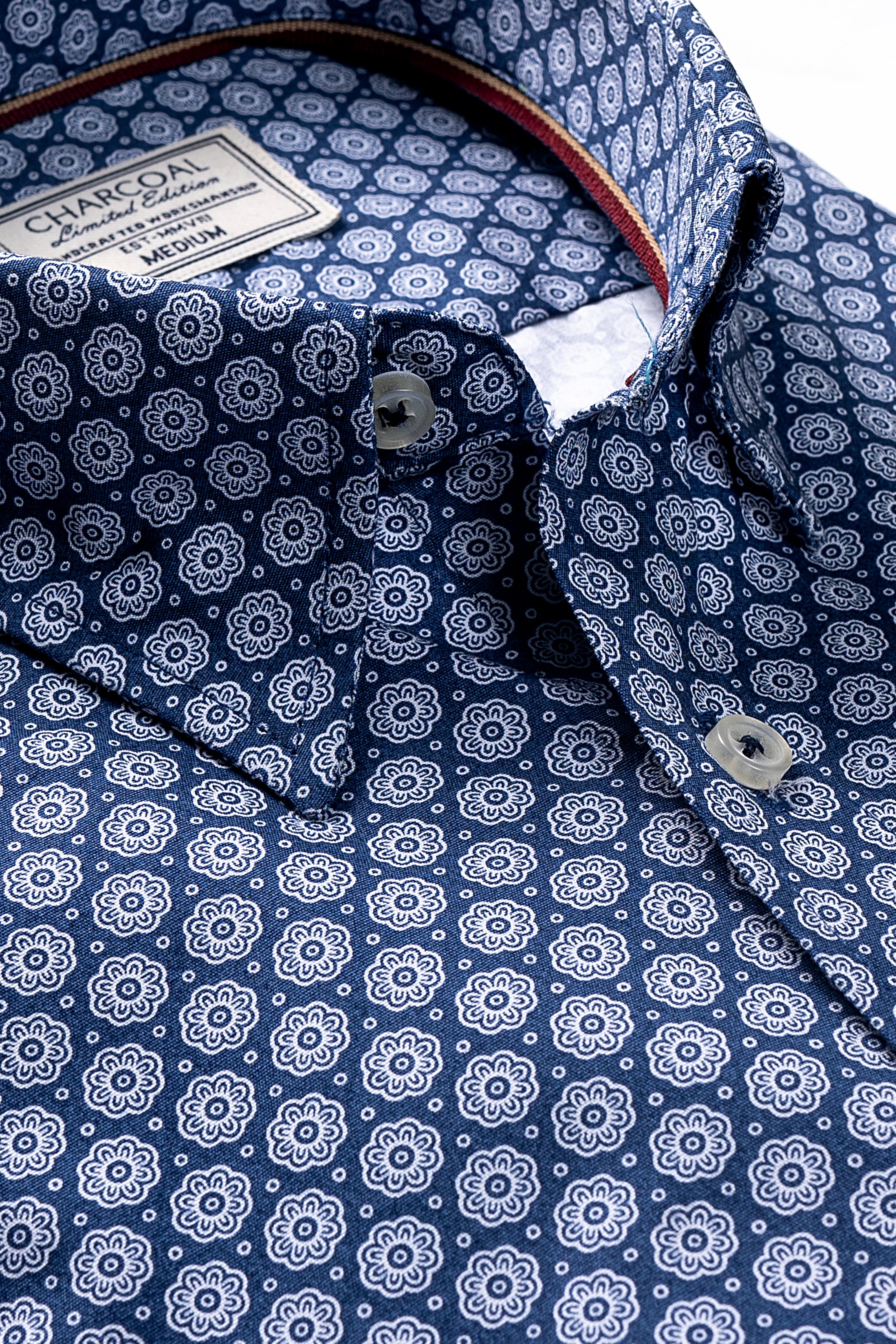 Blue dress shirt close-up: white medallion print, collar tag, button placket