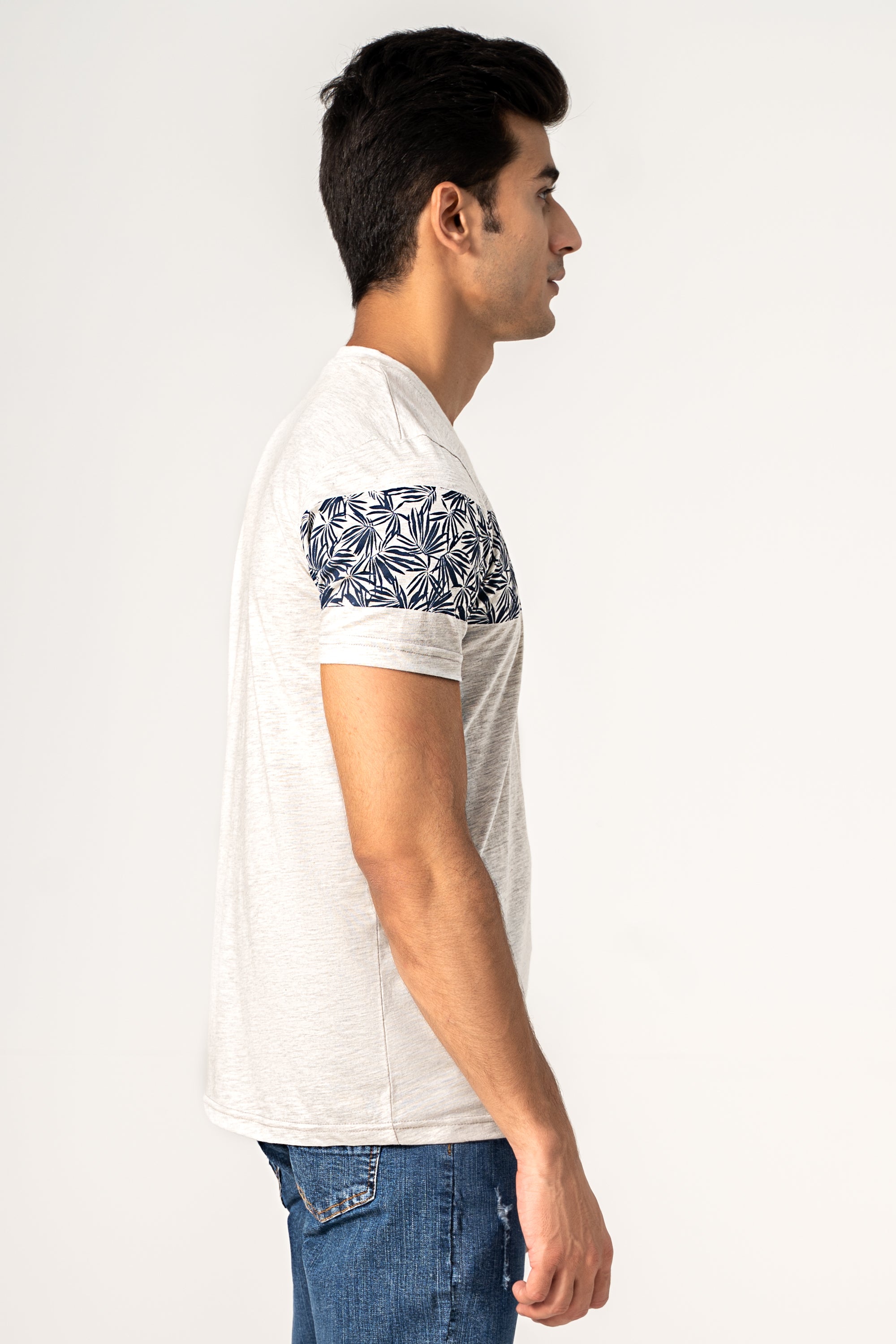 Off-white T-shirt with blue leaf print on sleeve and chest; short sleeves
