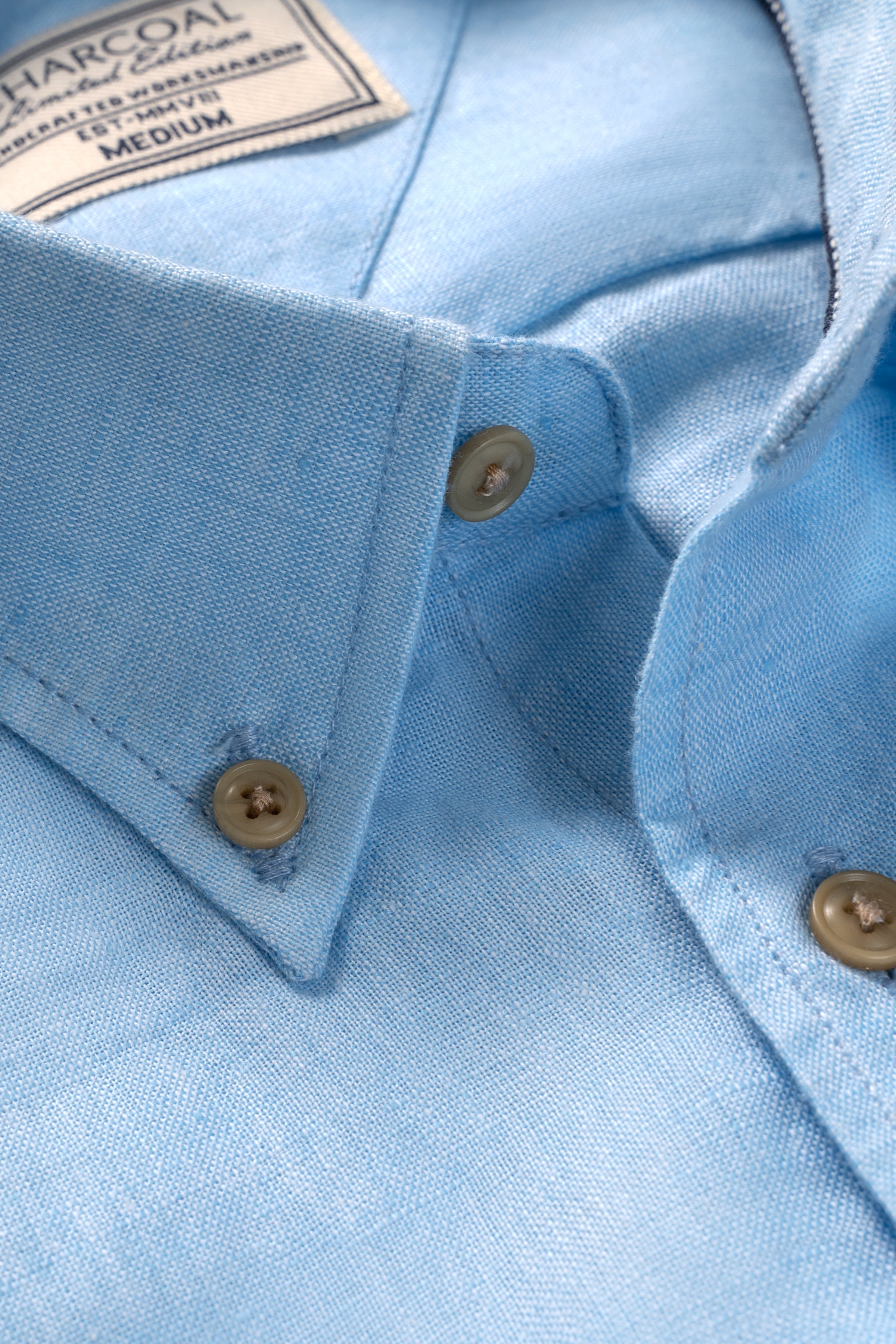Sky blue linen shirt showing button placket and collar seam