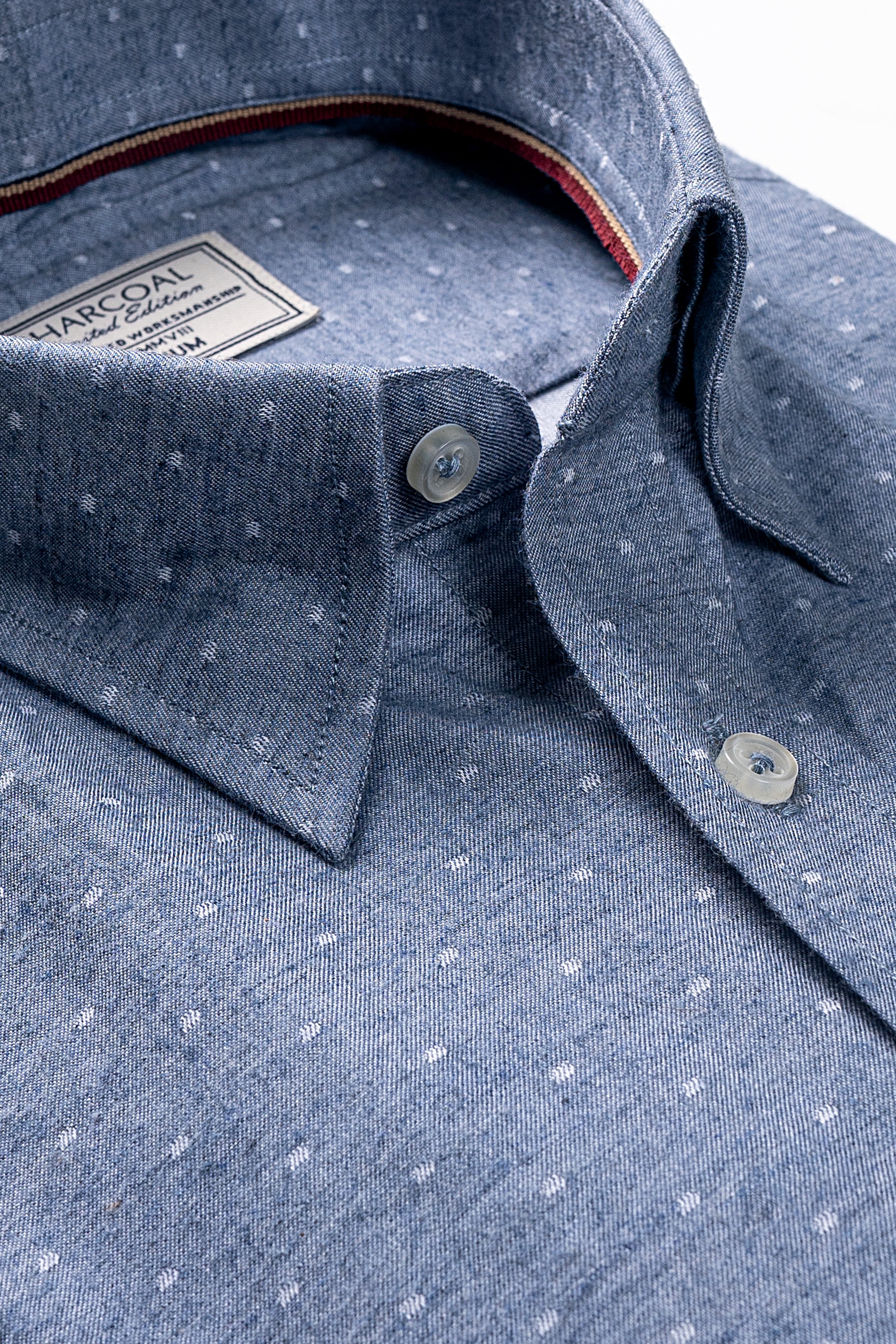 Chambray blue shirt close-up with button-down collar and speckled fabric texture