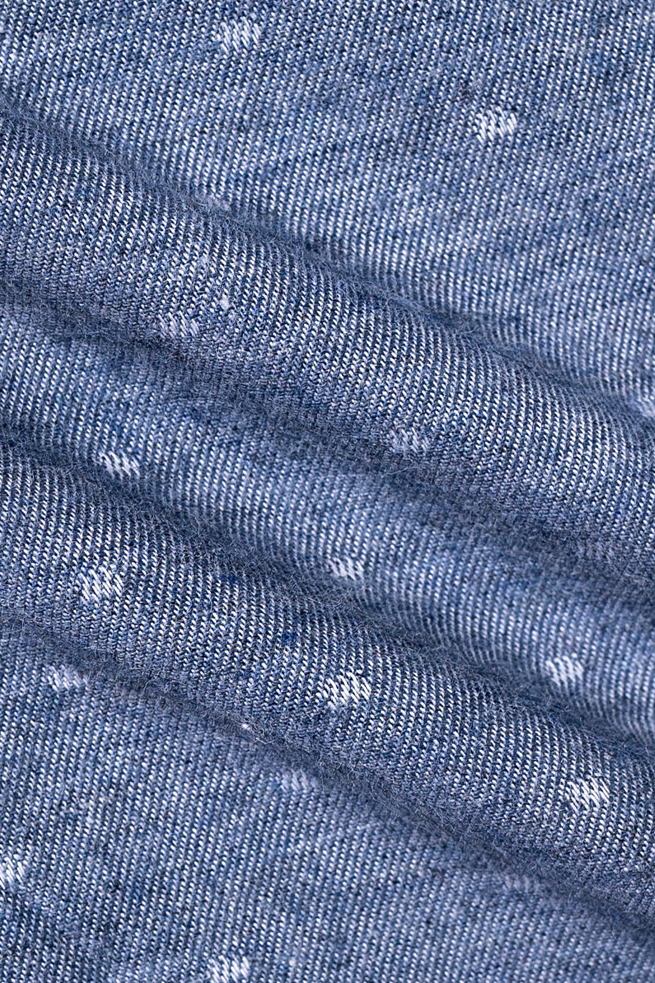 Chambray blue fabric close-up with woven texture and small speckled flecks
