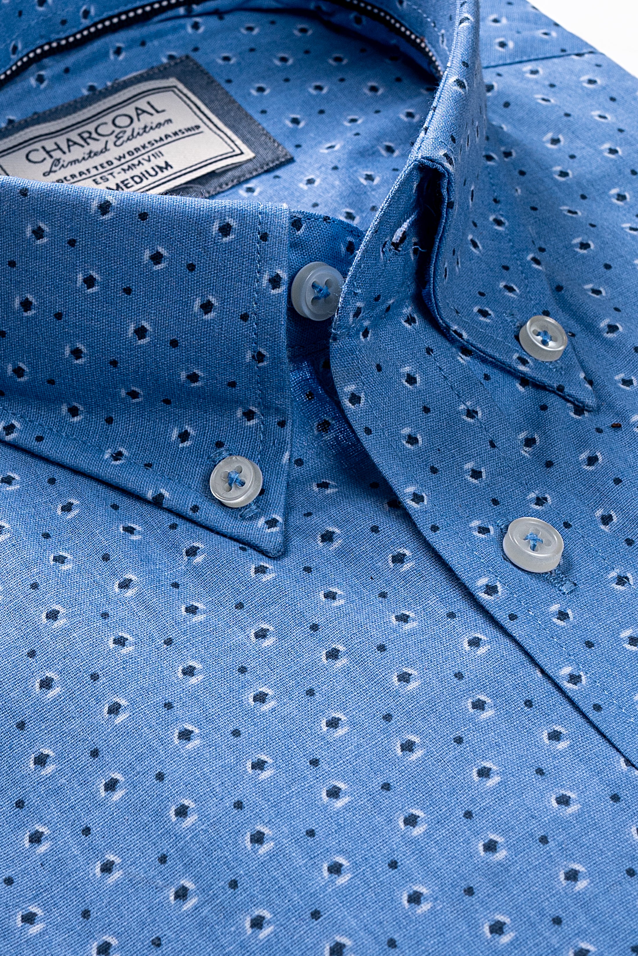 Sky blue dress shirt detail with brand label, button placket and dotted texture