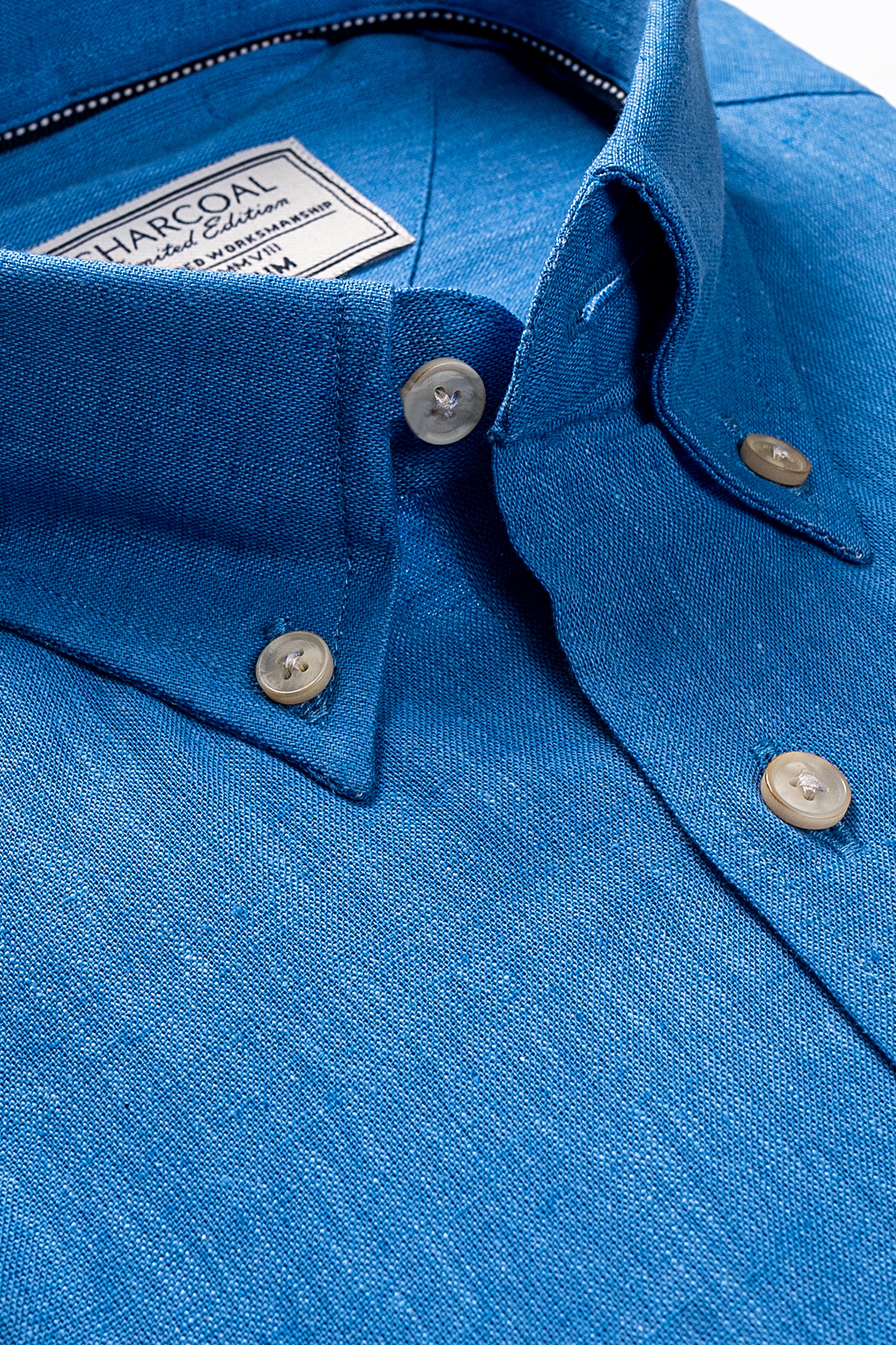 Blue linen shirt close-up: buttoned collar, front placket, gold-tone buttons