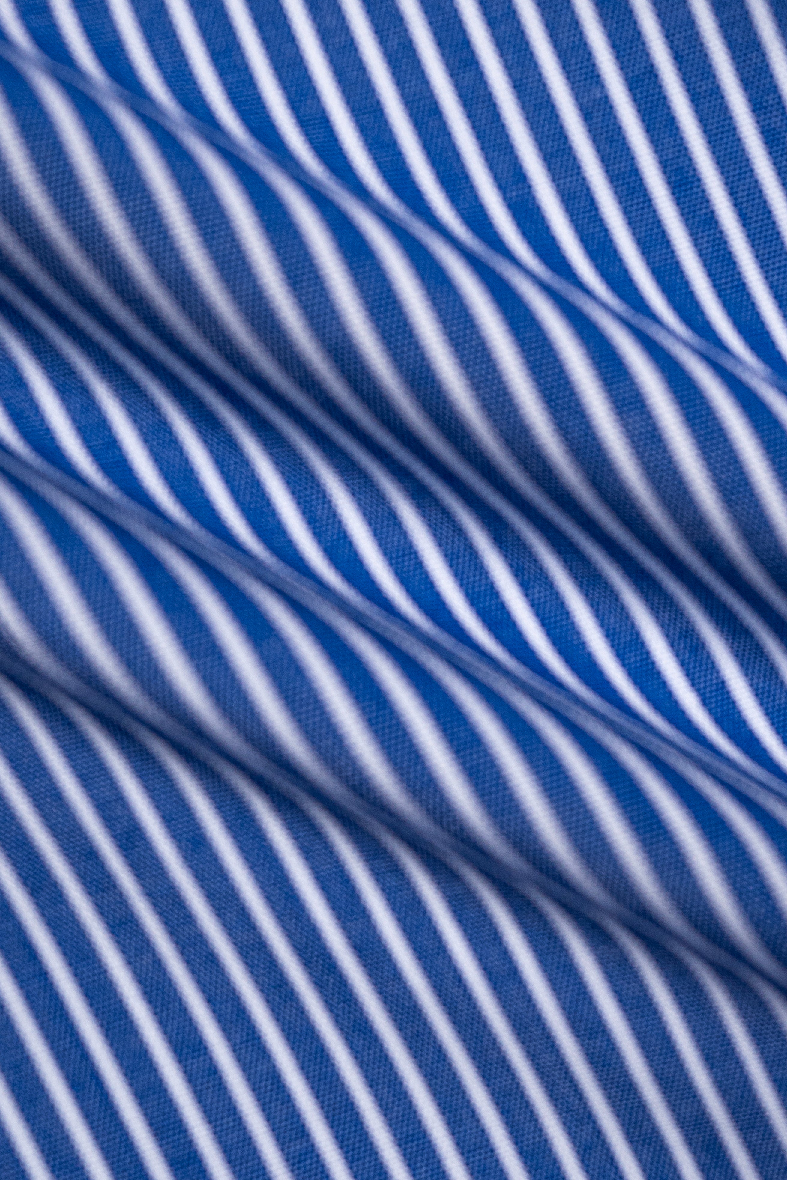 Limited edition blue striped shirt fabric close-up with wavy pinstripes