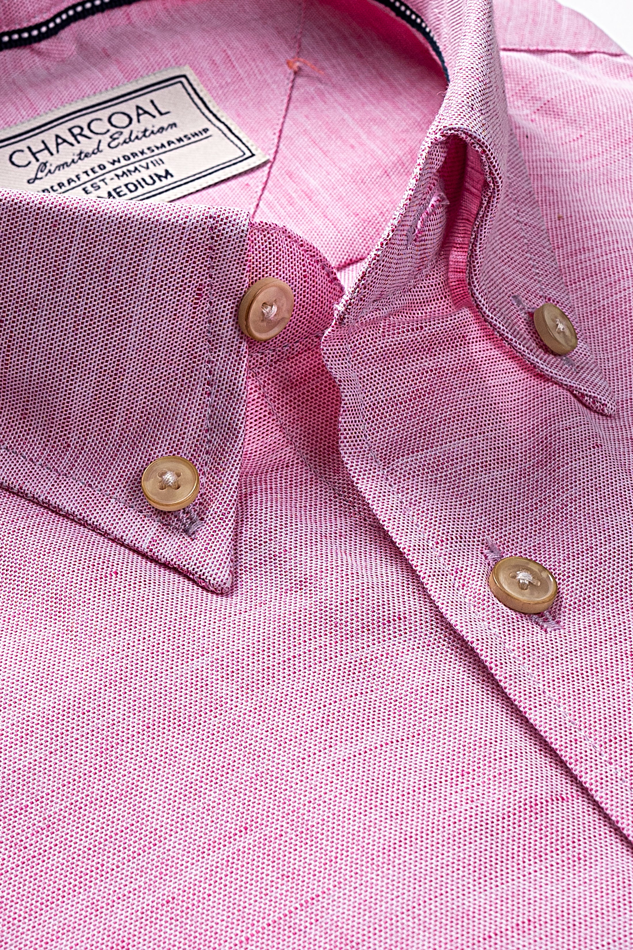 Pink linen shirt close-up: button-down collar with gold buttons and label