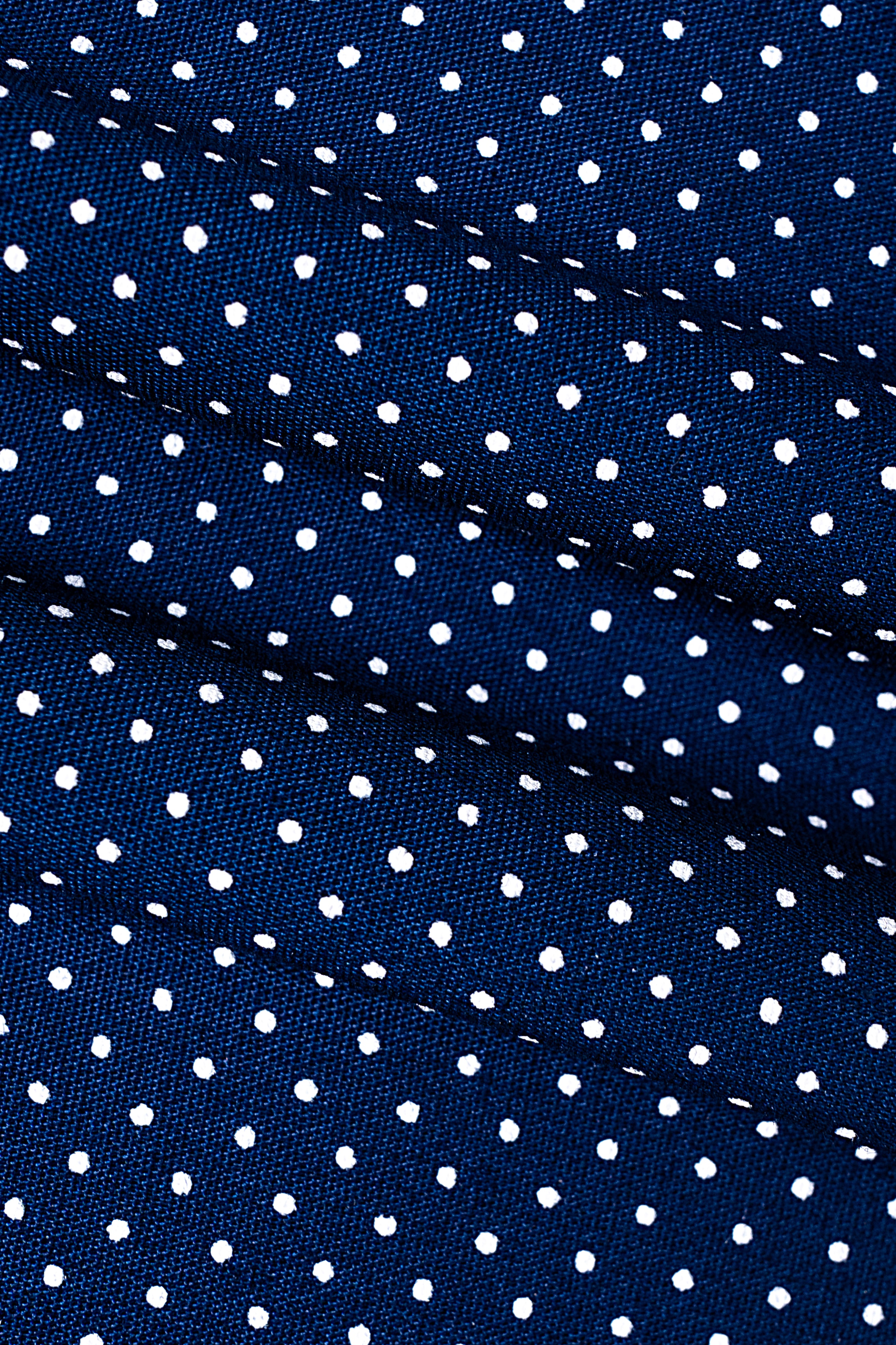 Navy fabric with scattered white dot pattern, close-up