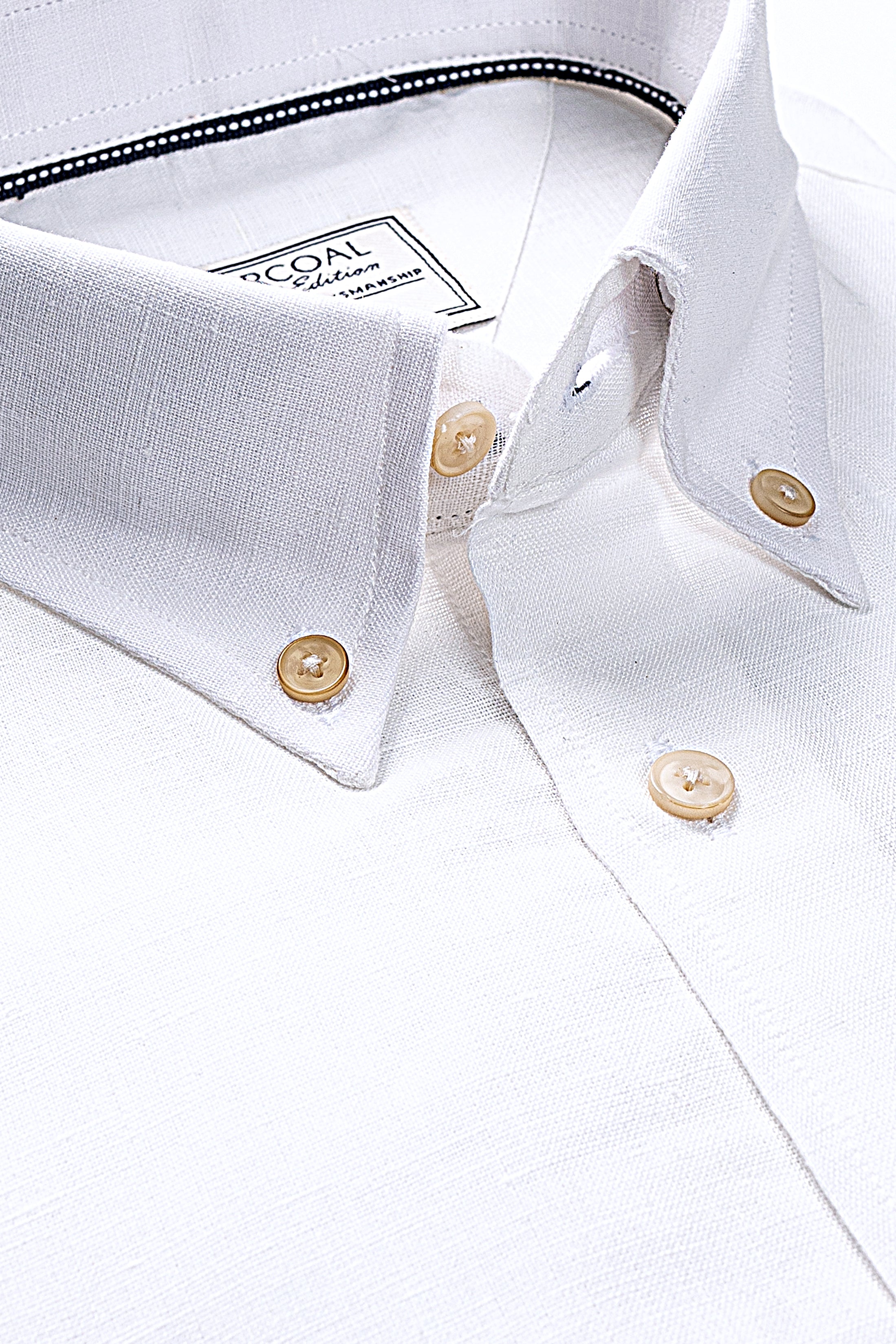 Off-white linen shirt close-up of collar and gold-tone buttons