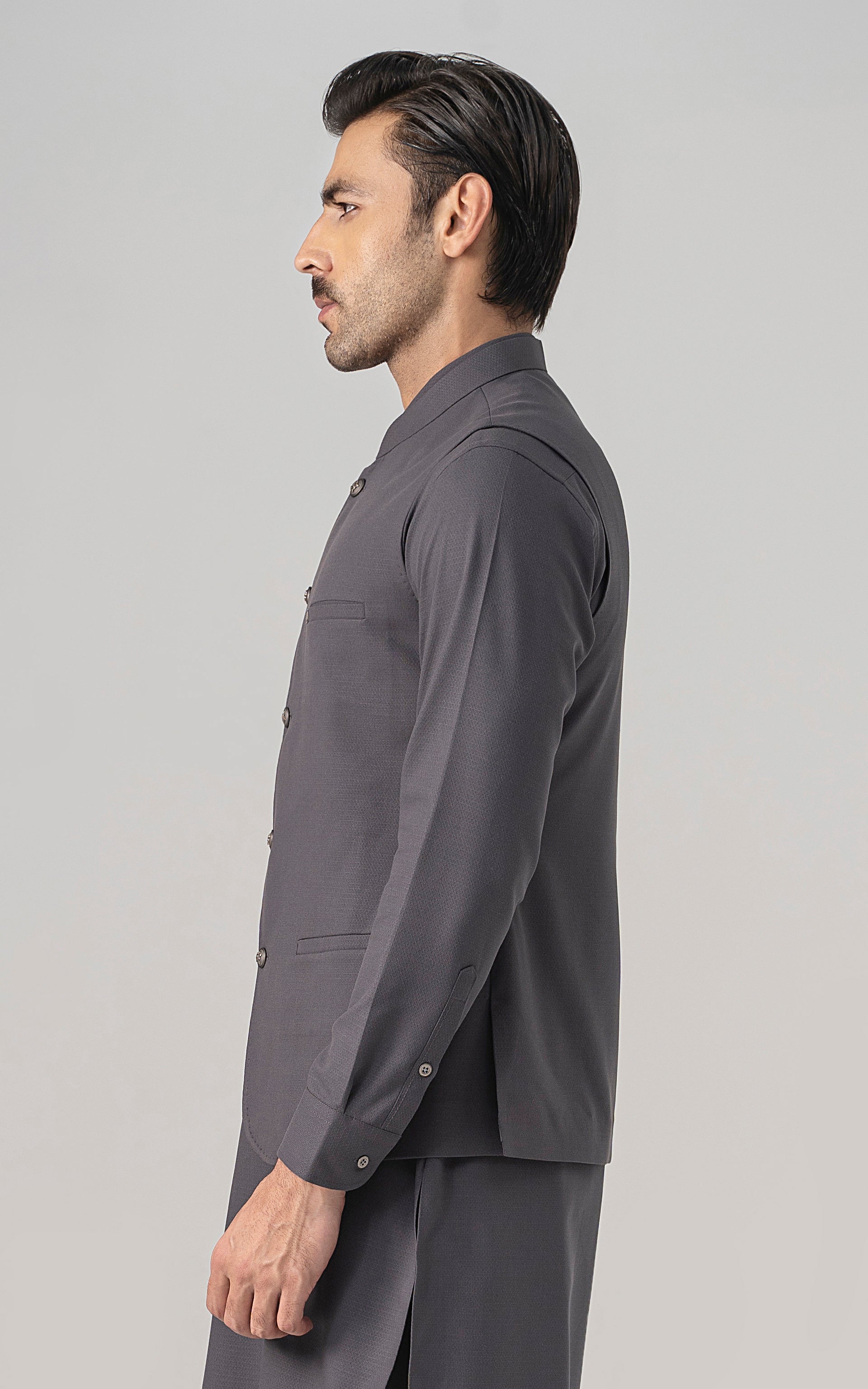 Mid-grey textured waistcoat on model, side view with button front