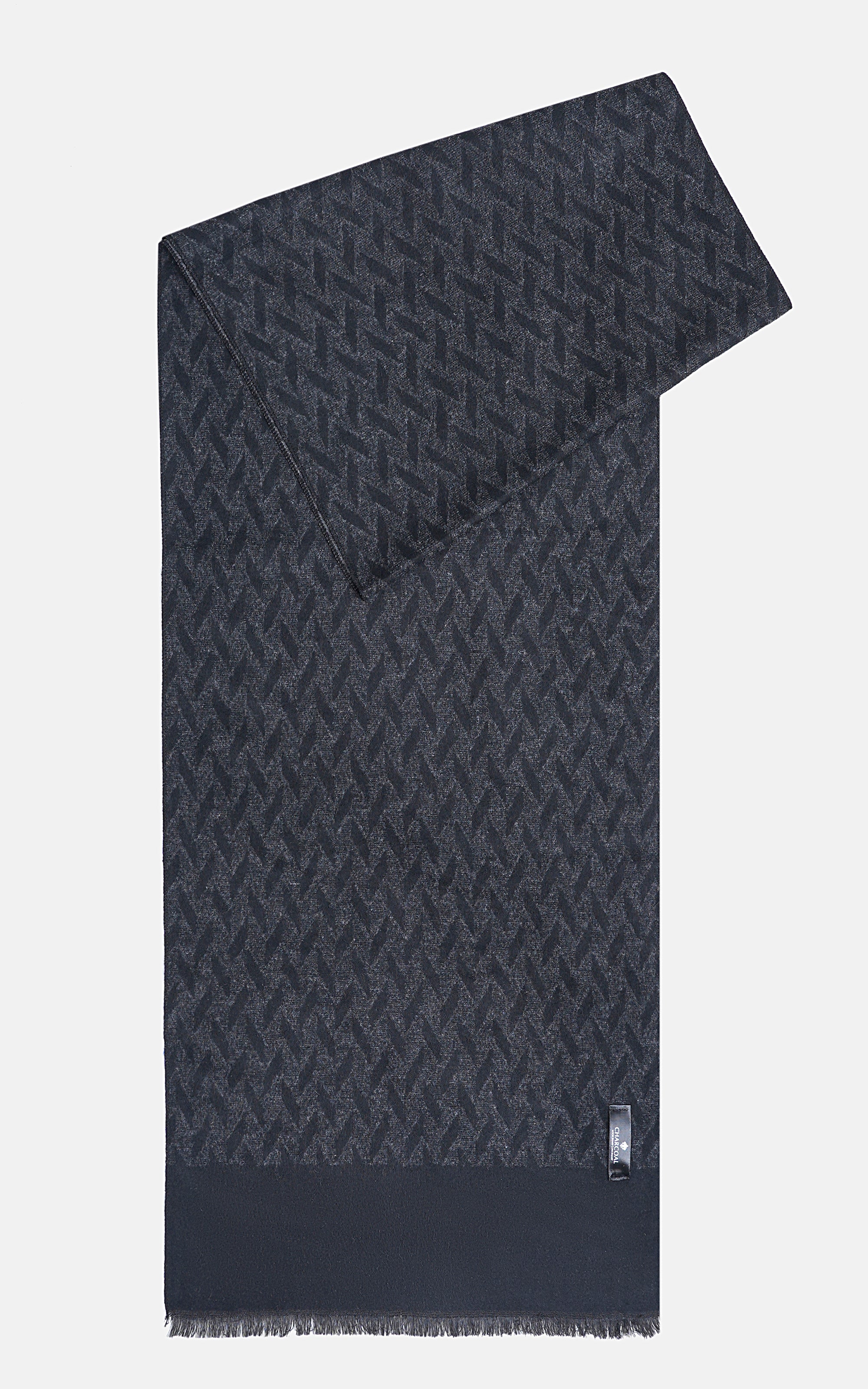 Dark patterned scarf draped diagonally, fringed ends and small square tag