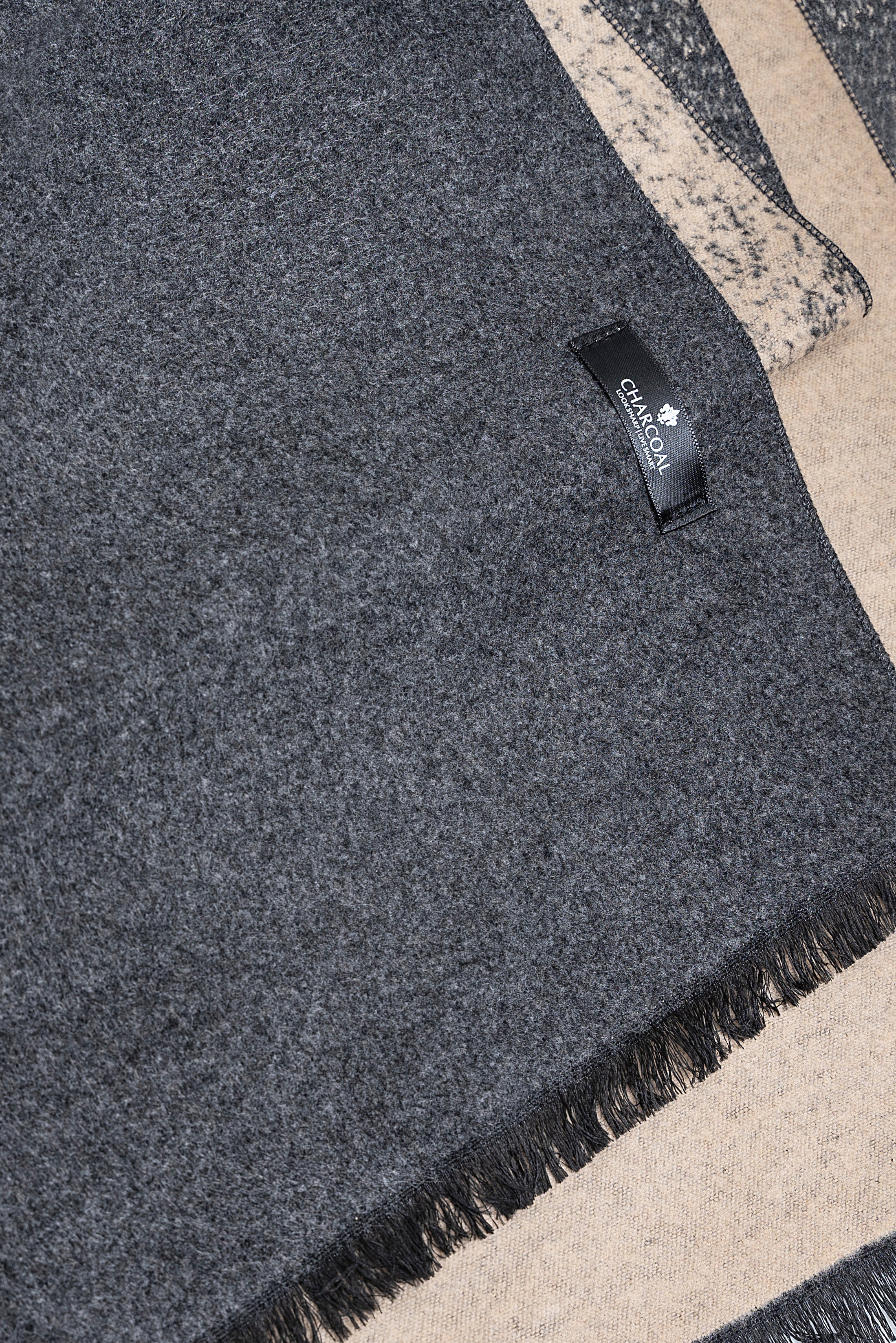 Speckled dark gray scarf corner with short fringe and stitched brand label