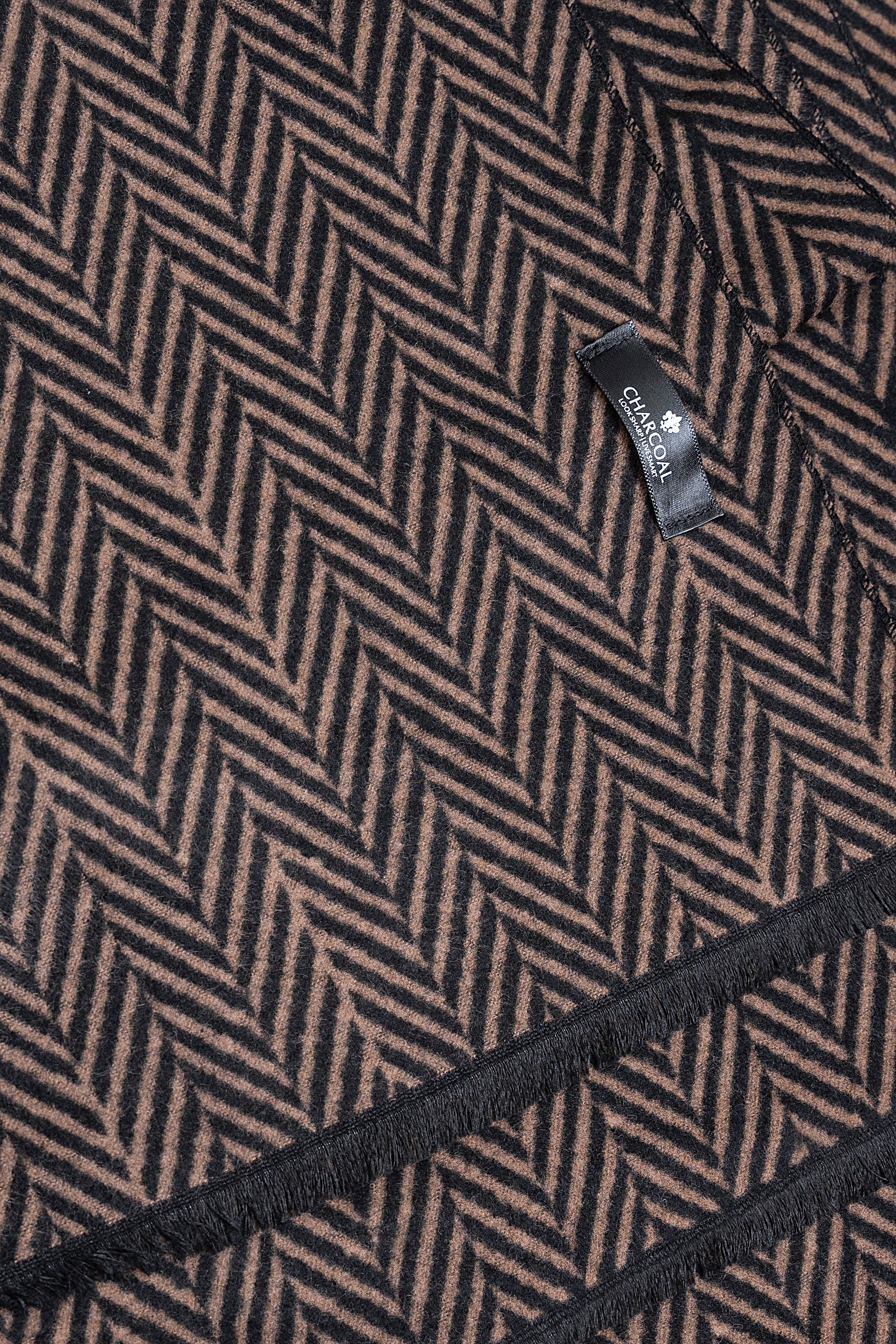 Herringbone scarf fabric close-up with small woven brand label