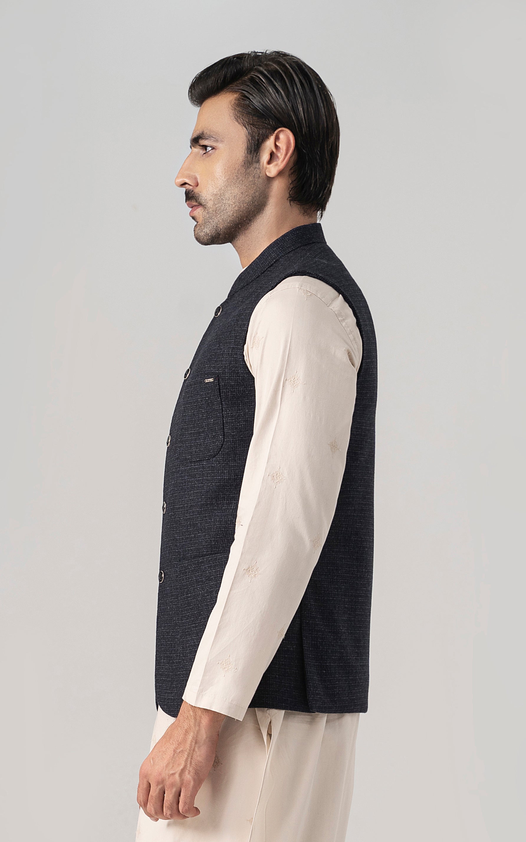 Navy textured waistcoat with button placket, worn over a cream shirt sleeve