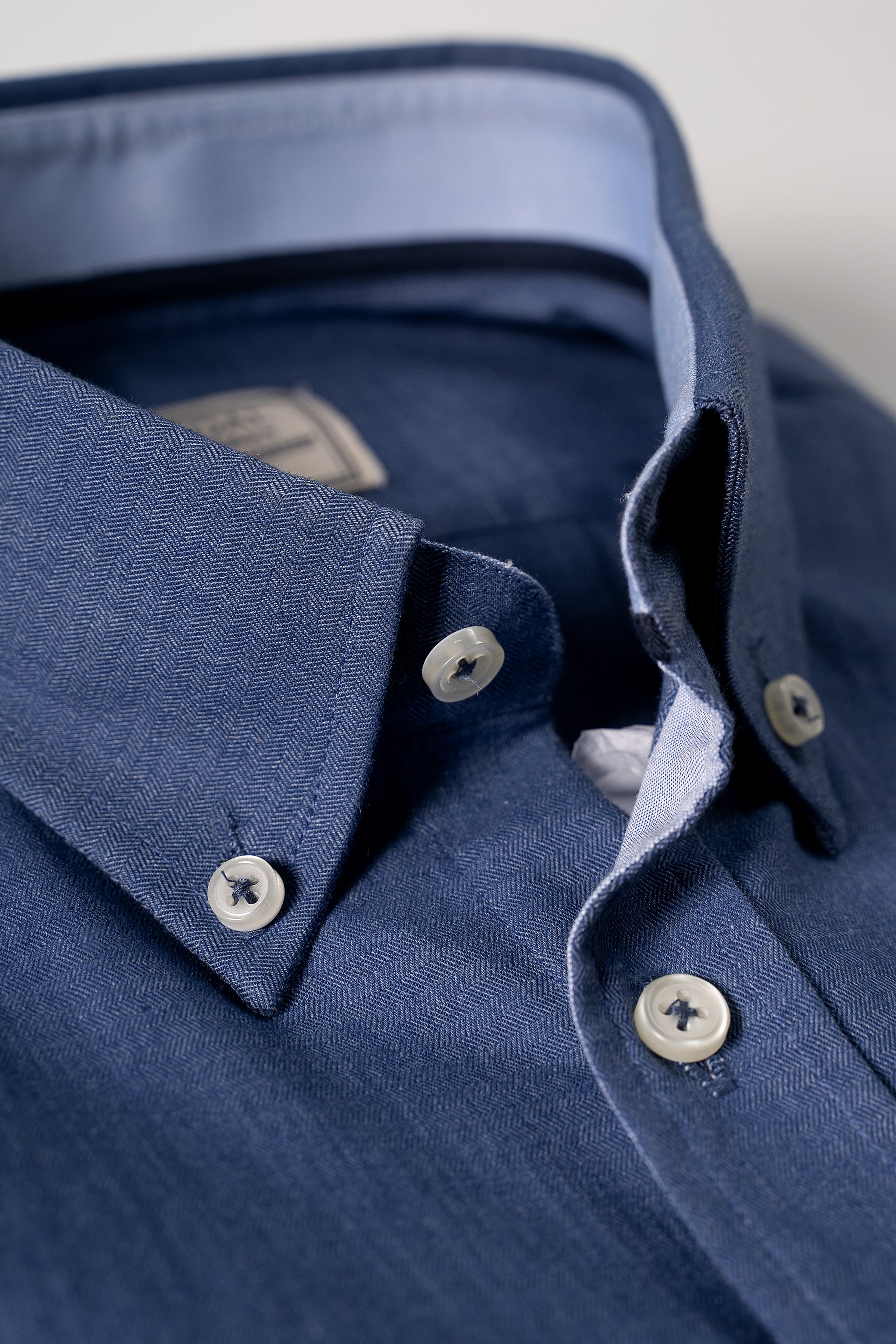 Blue button-up shirt collar and placket with white buttons
