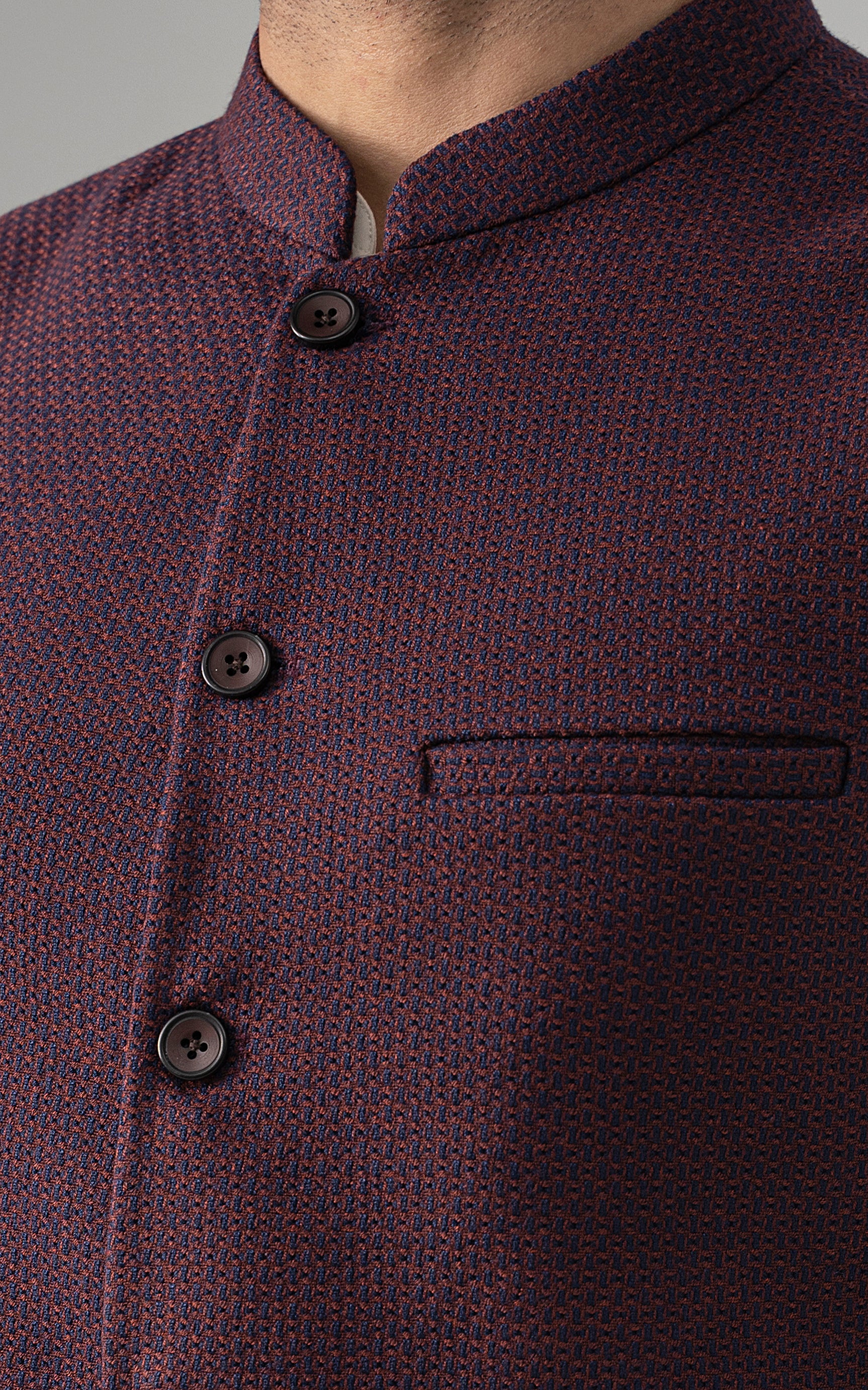 Maroon textured waistcoat with buttoned front and rectangular chest welt pocket
