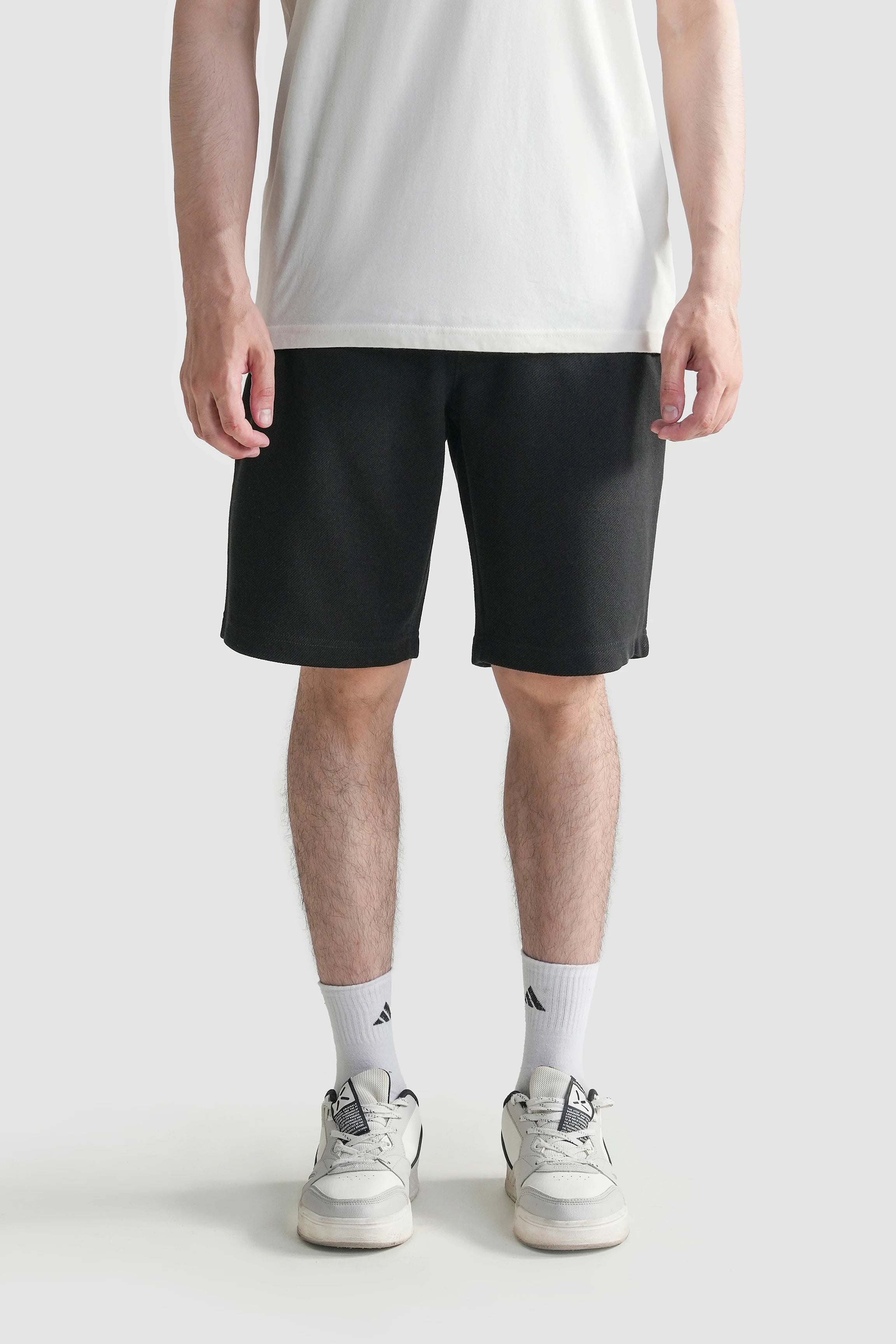 Black regular-fit shorts with elastic waistband, drawstring, and side pockets