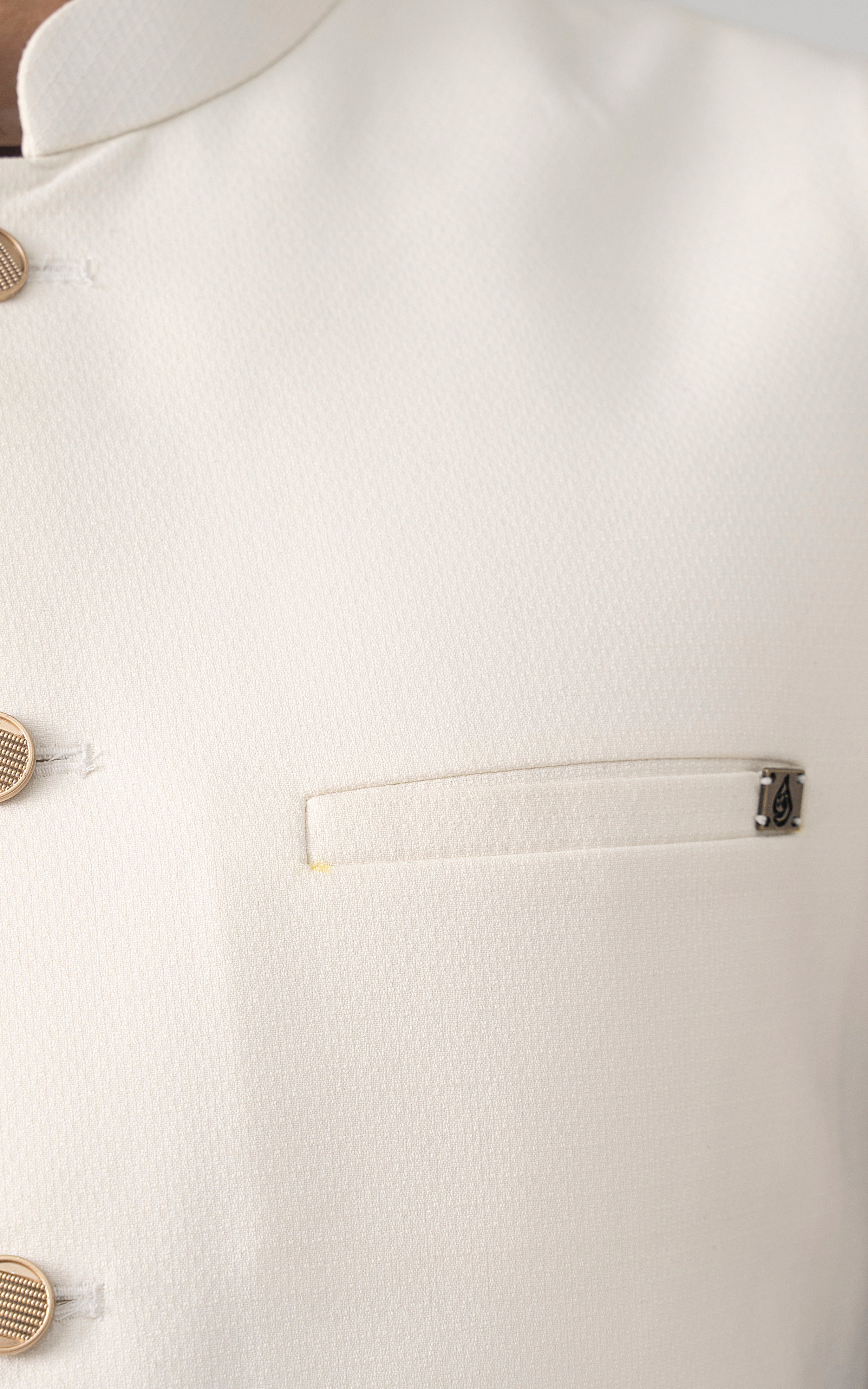 Off-white textured waistcoat chest pocket with welt and small metal clasp accent.