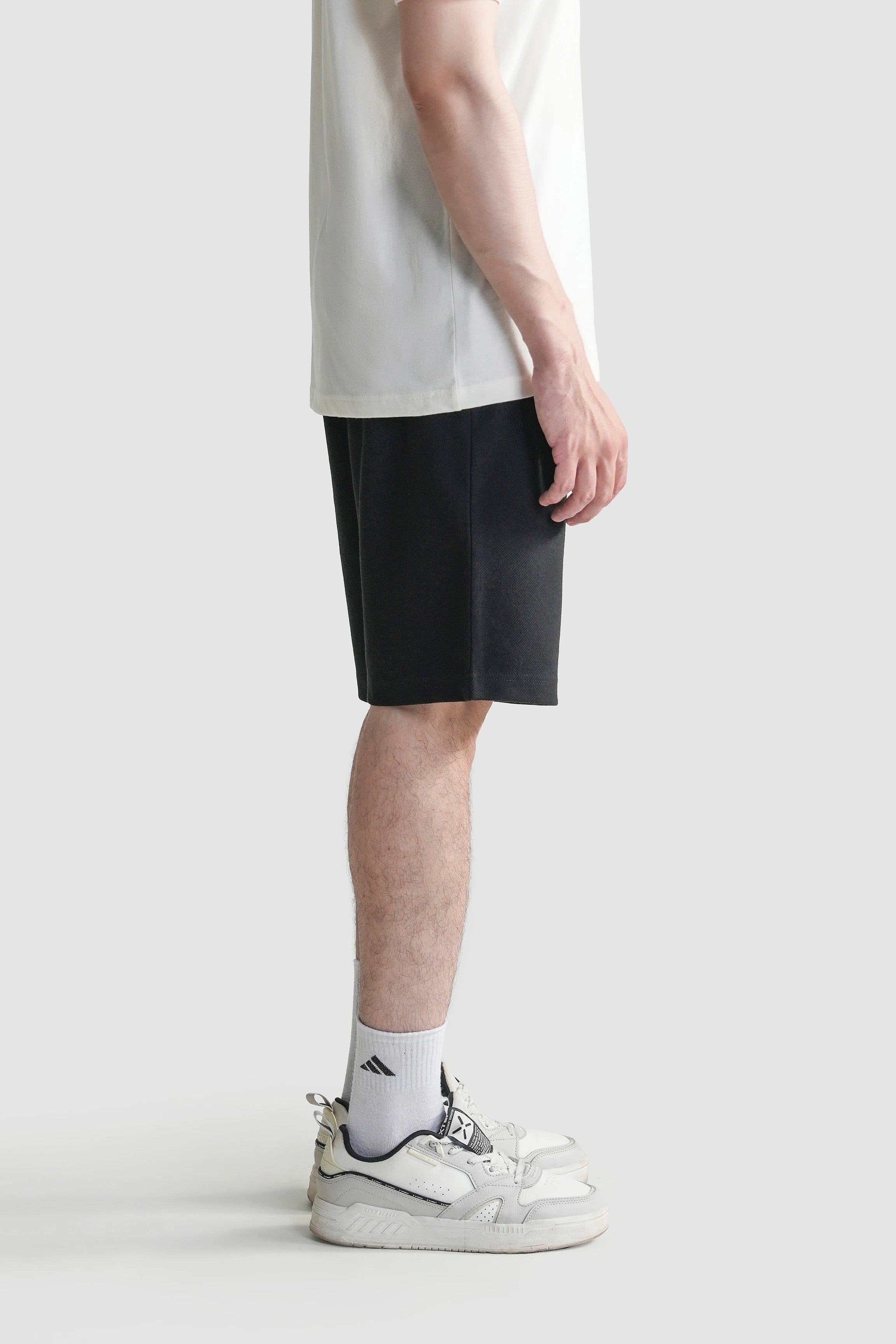 Black regular-fit shorts with elastic waistband and drawstring, side view