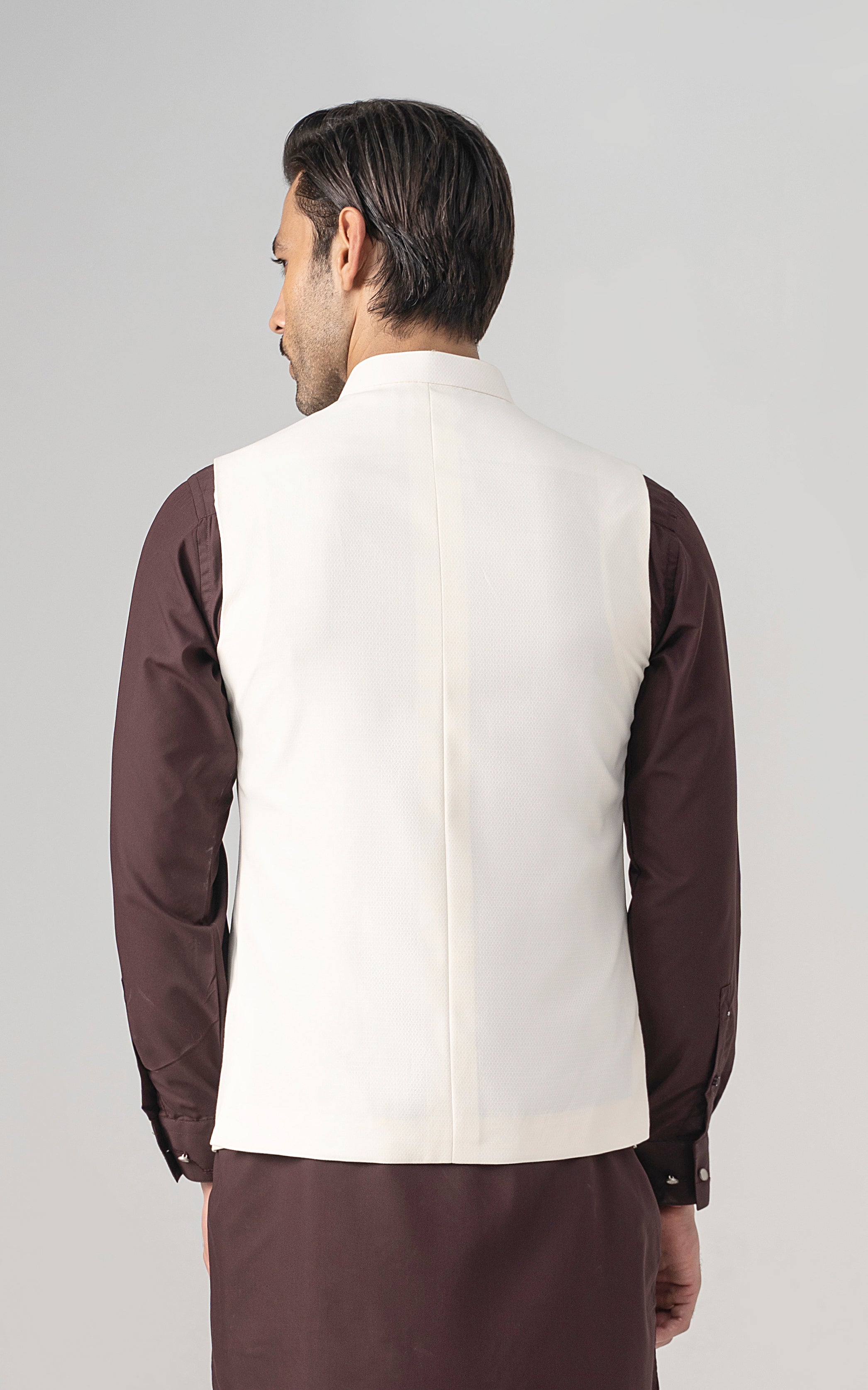 Back view of off-white textured waistcoat with center seam and stand collar.