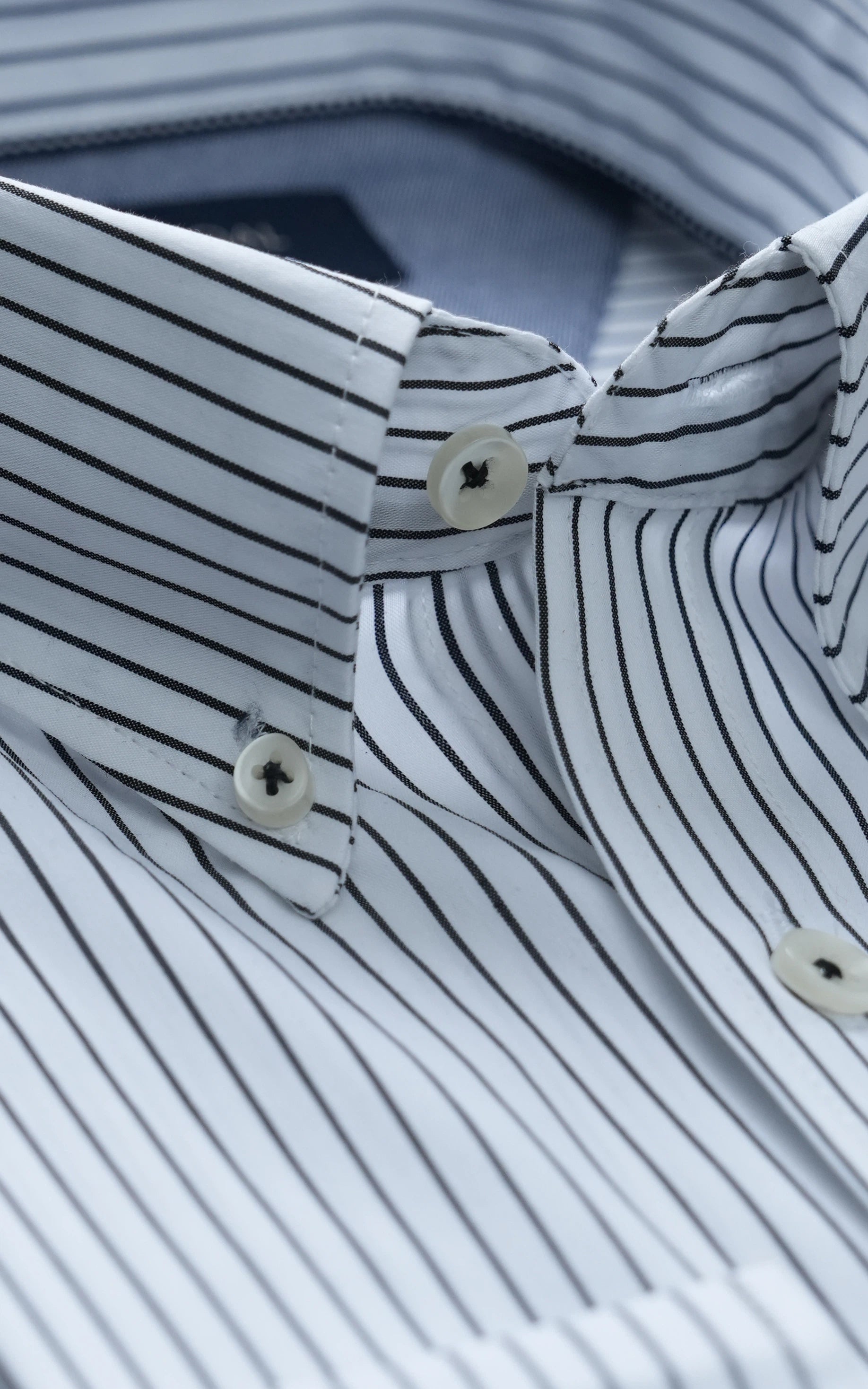 Pinstriped dress shirt collar with button placket and white buttons
