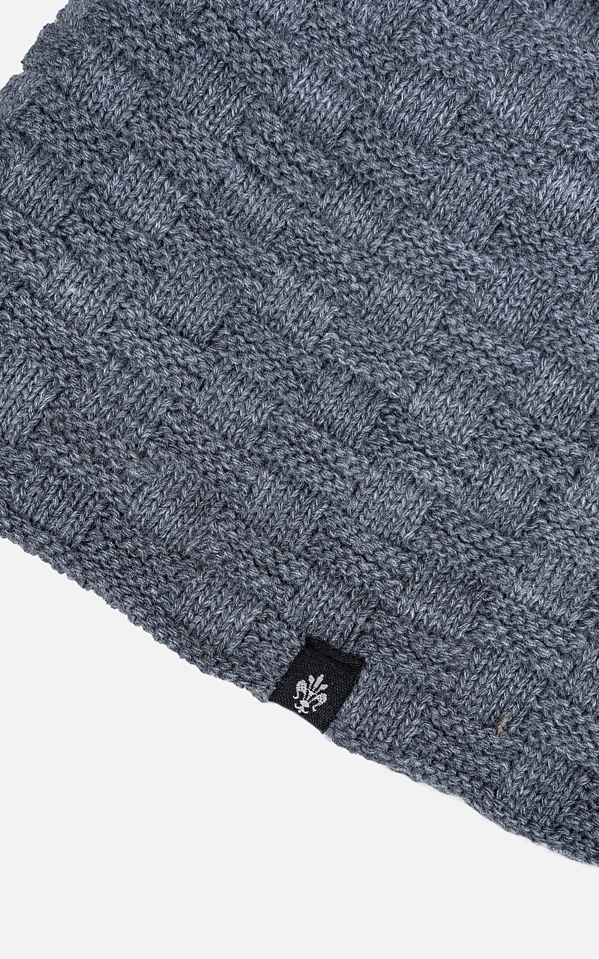 Wool cap fabric close-up in blue knit texture with small logo detail