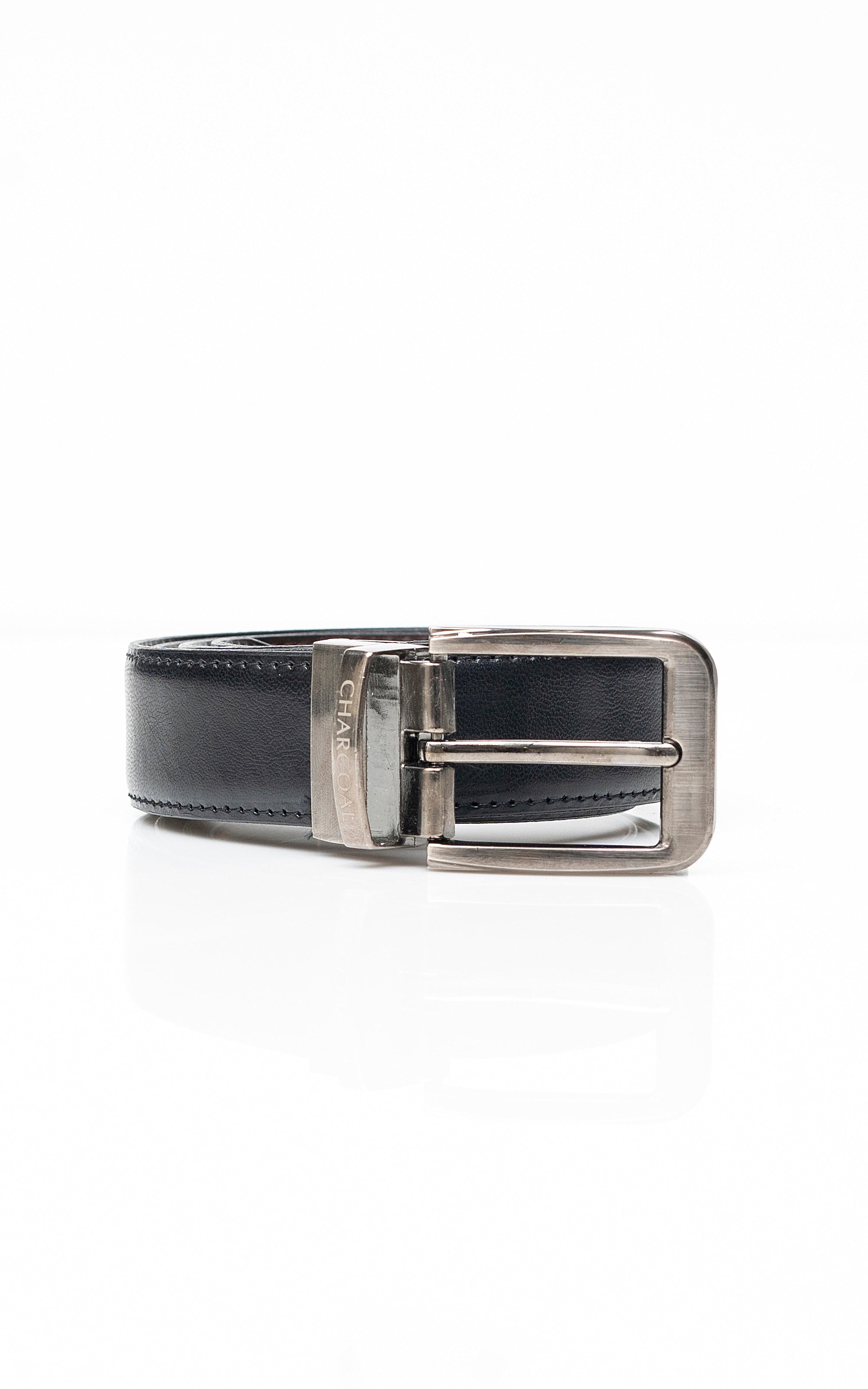 Reversible belt buckle close-up with dark leather strap and brushed silver square hardware.