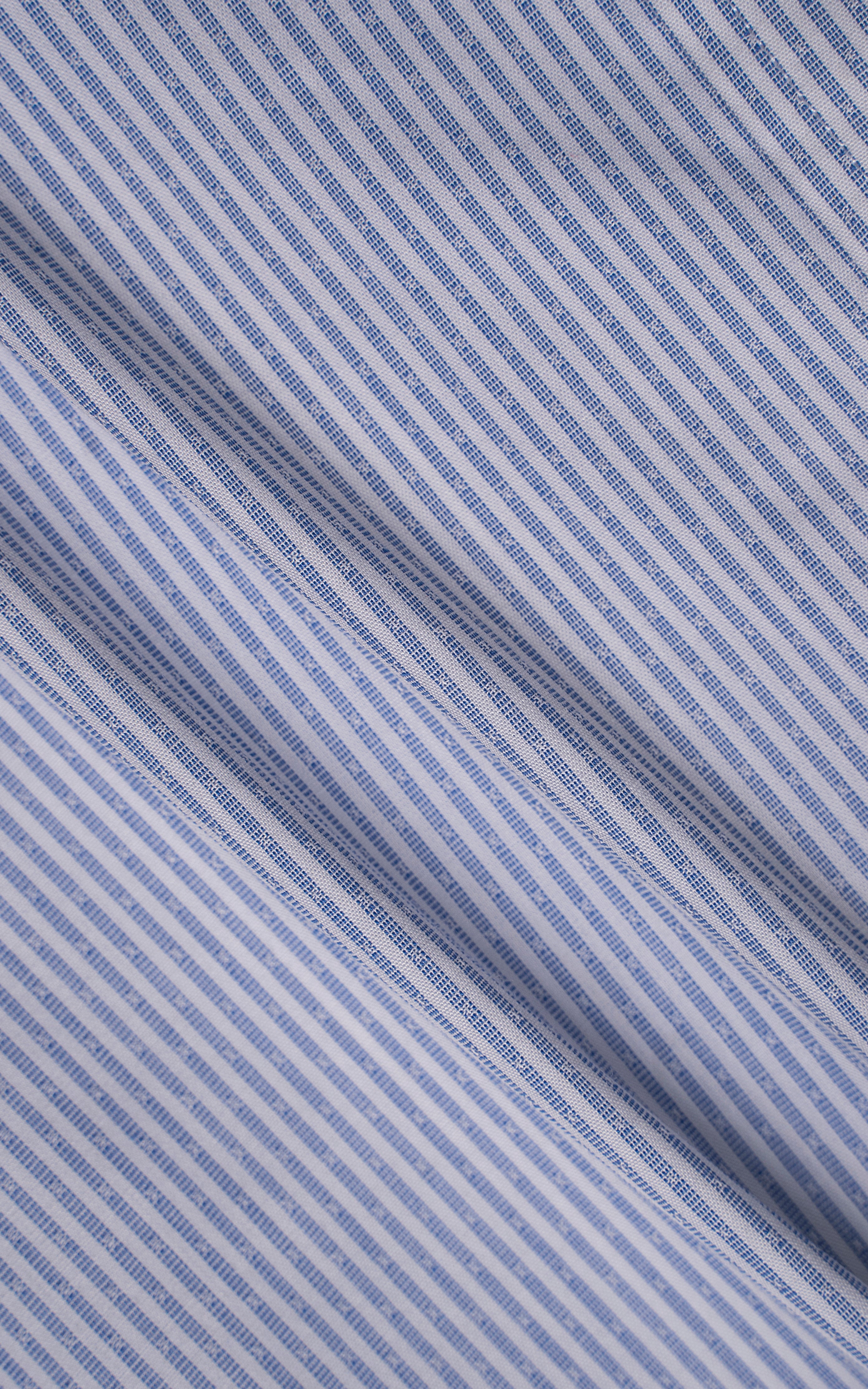 Blue pinstripe shirt fabric close-up with fine woven texture and diagonal stripe pattern